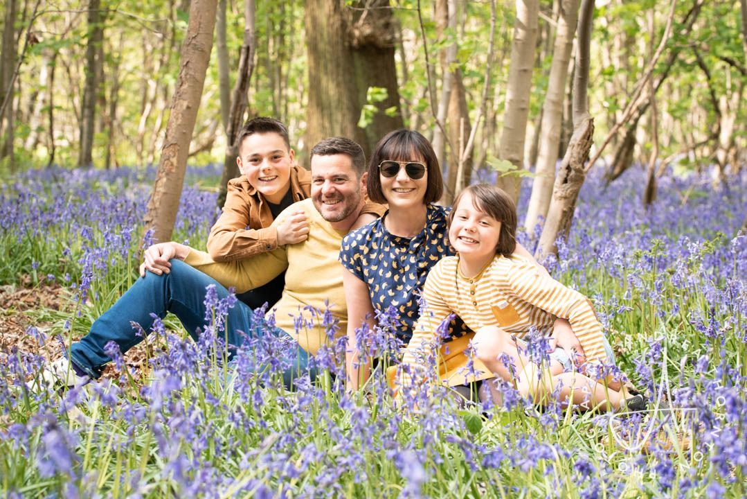 Family sitting in the bluebells during a spring photoshoot
