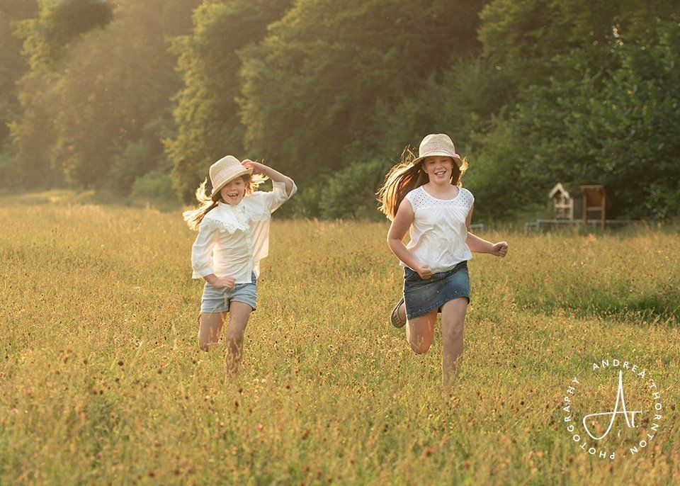 Girls running in the long grass during a family photoshoot in Leeds