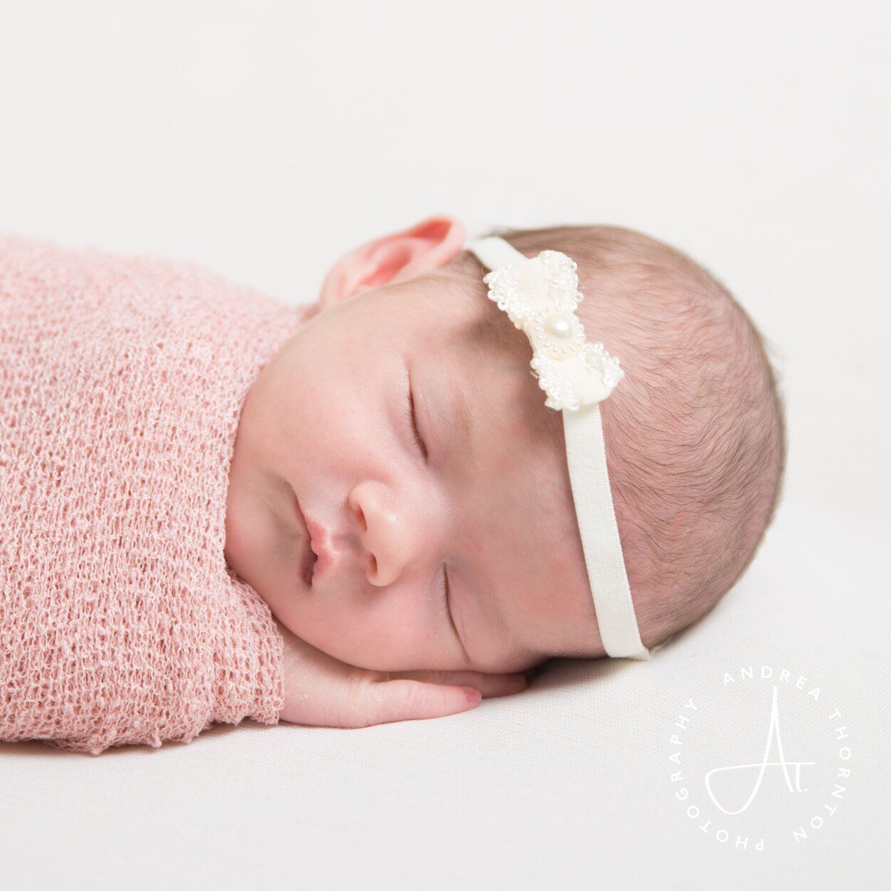 Sleeping baby girl during a photoshoot with newborn photographer Andrea Thornton