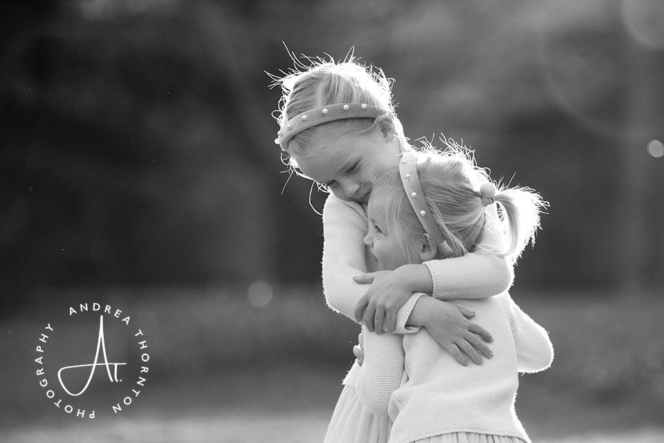 Sisterns embracing during a professional family photoshoot with Andrea Thornton