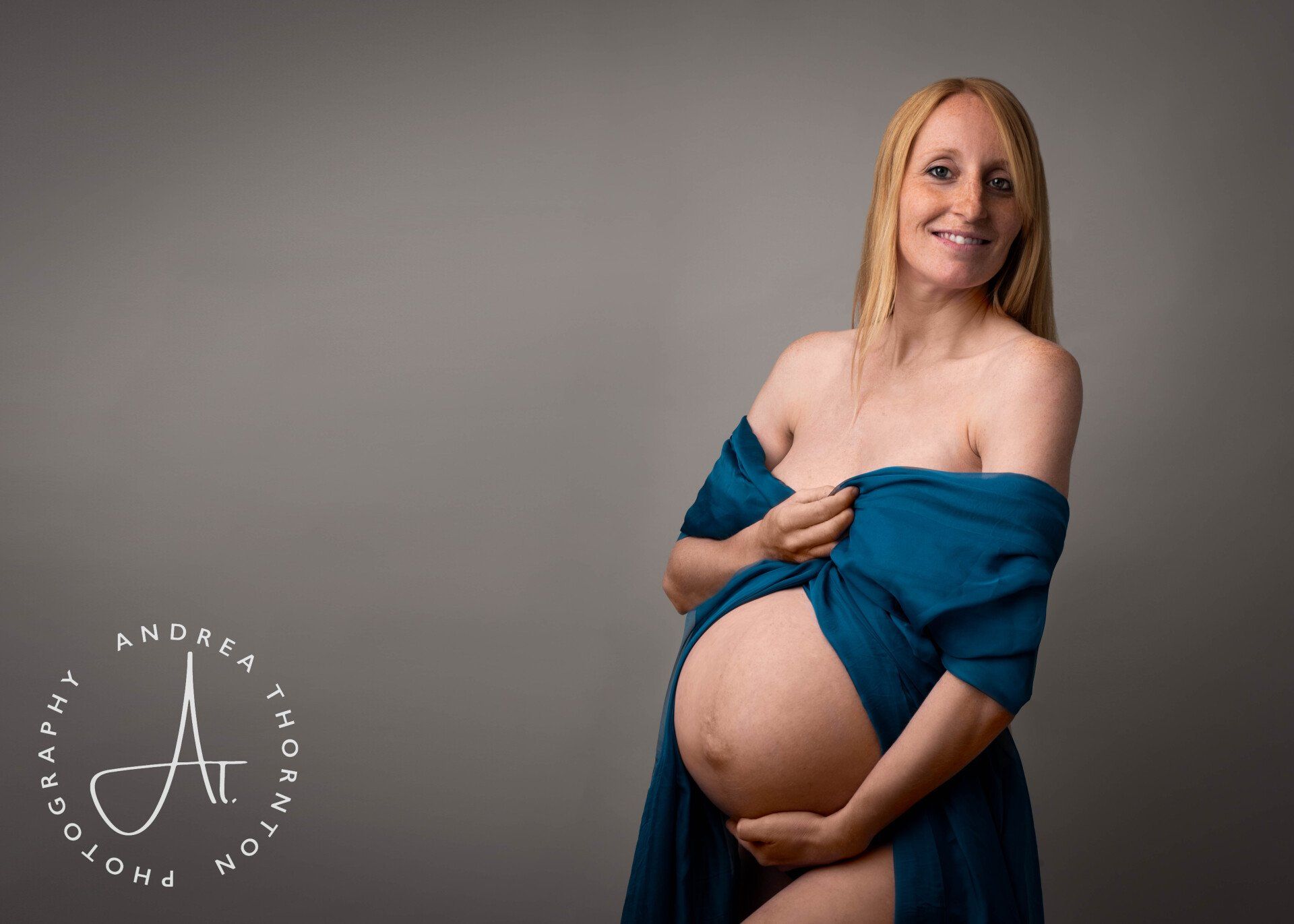 Smiling pregnant lady captured during a studio maternity photoshoot
