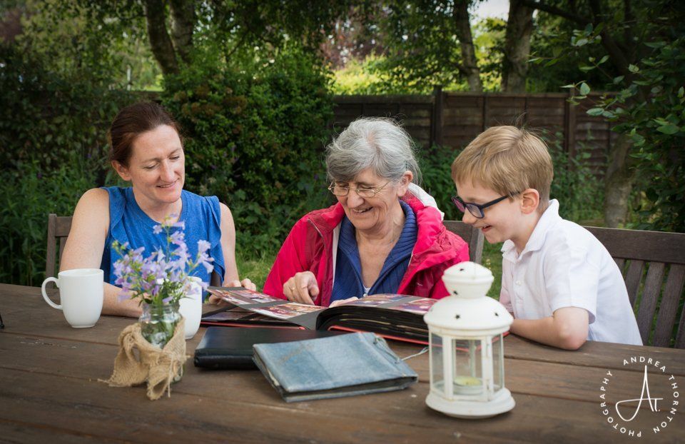 three generations of one family looking at an old photograph album