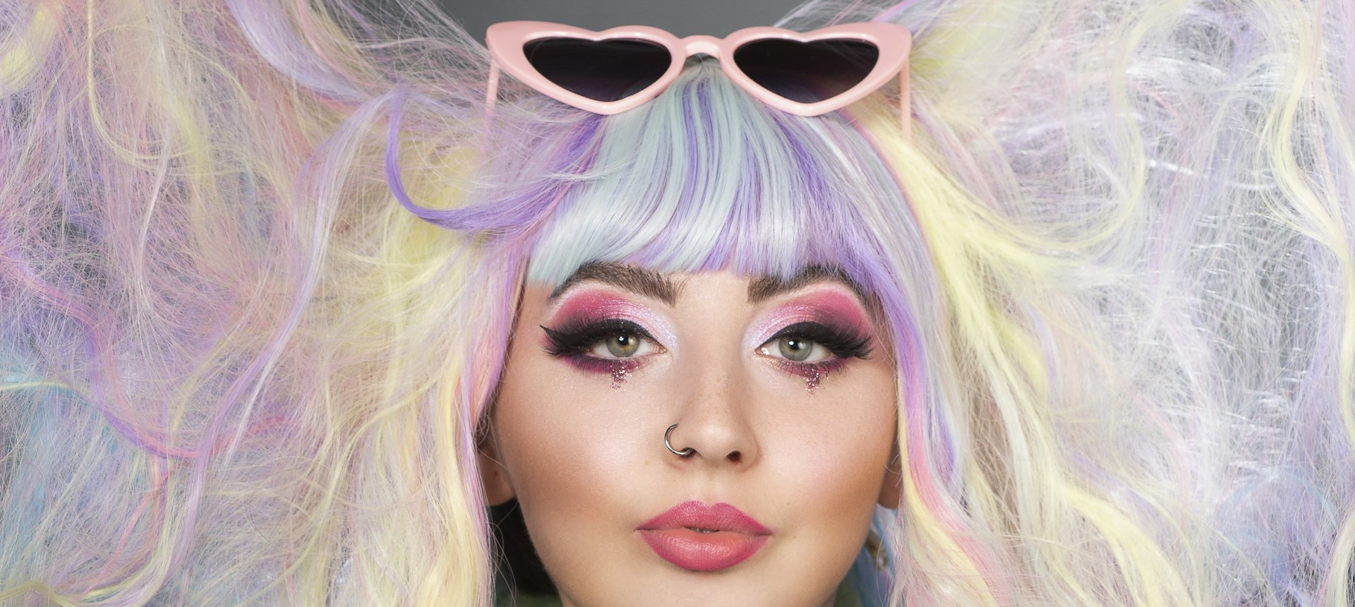 Alternative model with rainbow hair and heart sunglasses