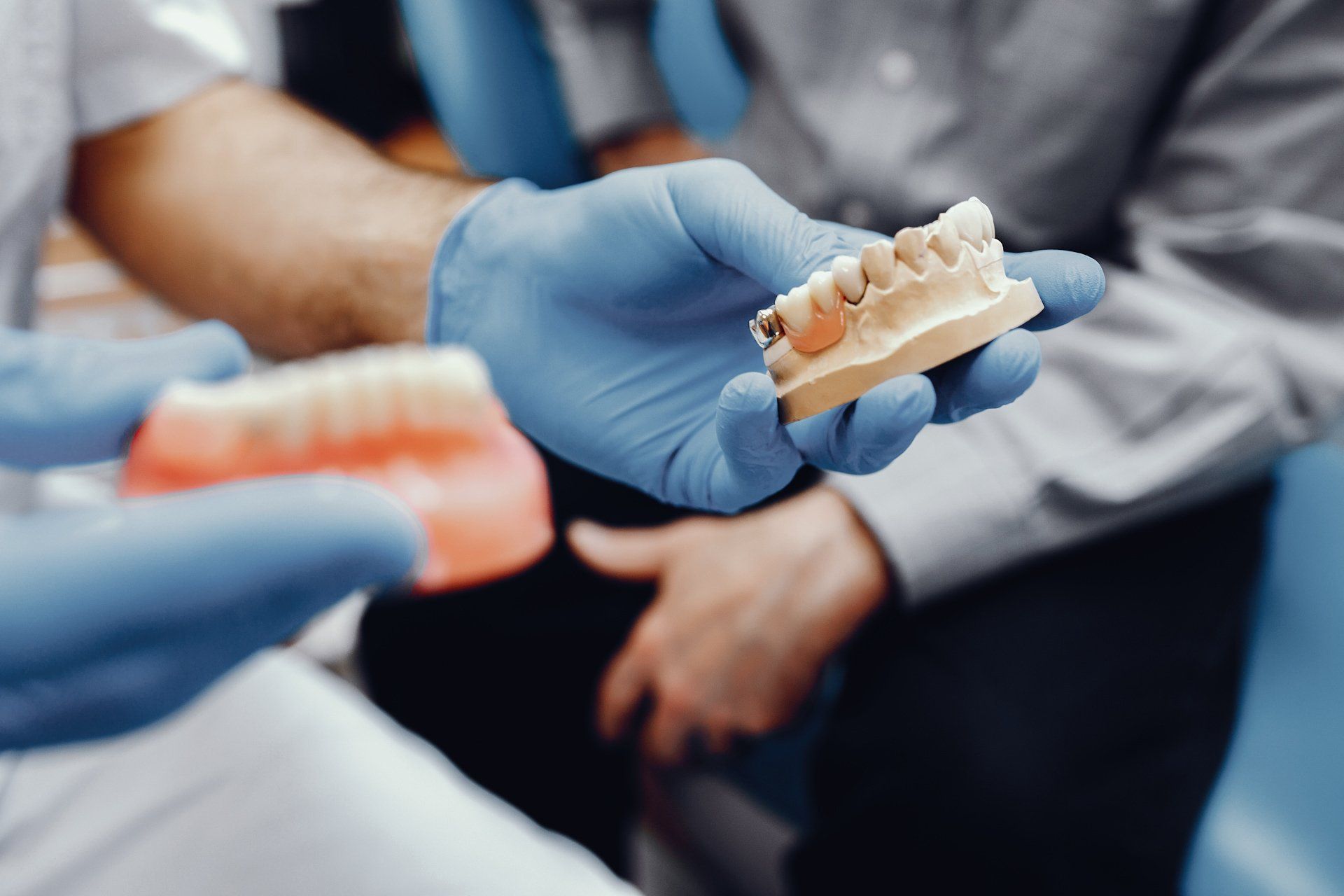 dentista sosteniendo implante dental con paciente