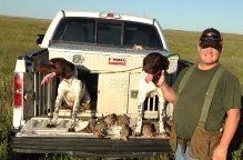 Two German Shorthaired Pointers, their Owner, and Pheasants after a Hunt