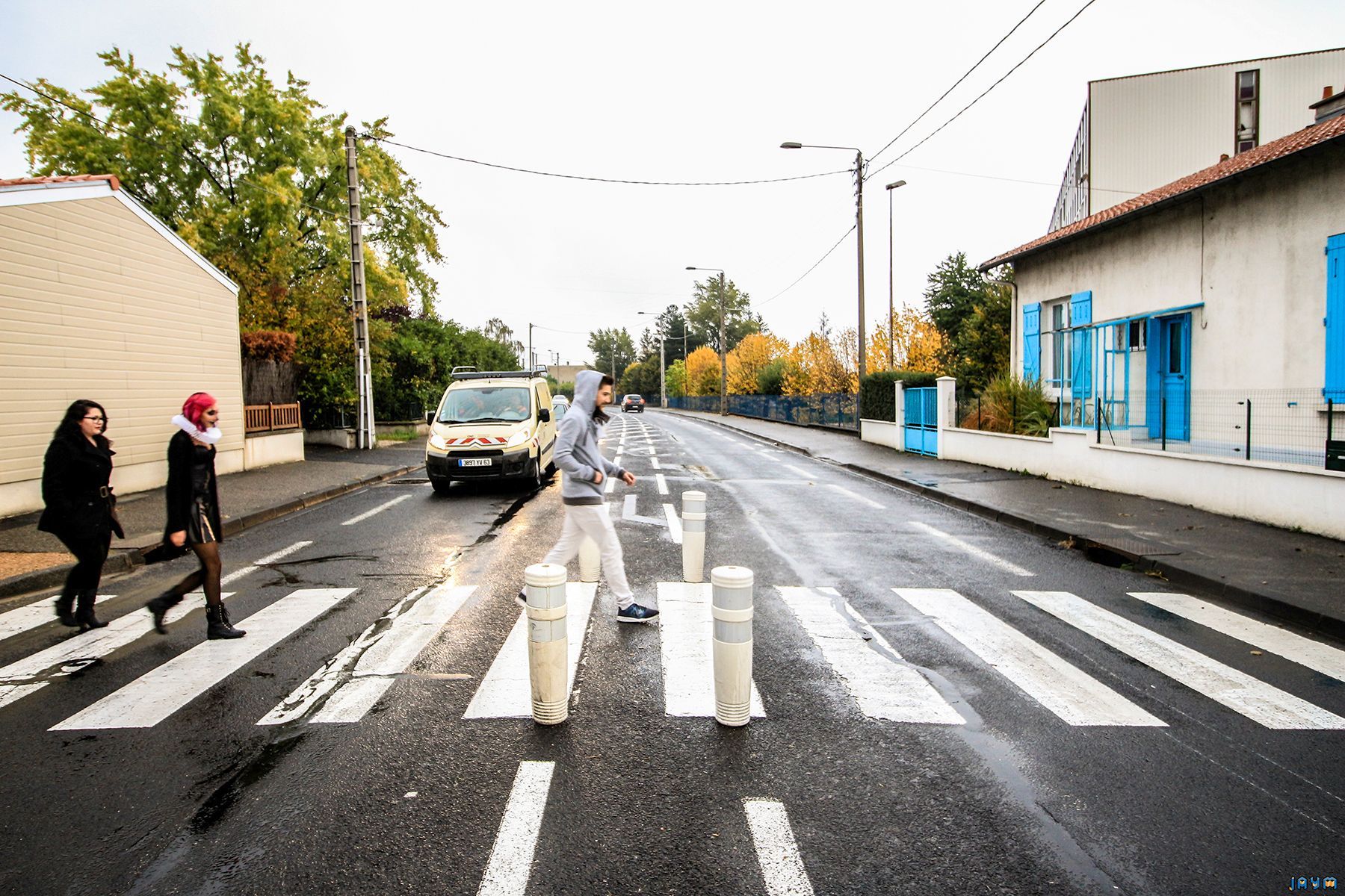 Un trio traverse une boulevard sur un passage piétons