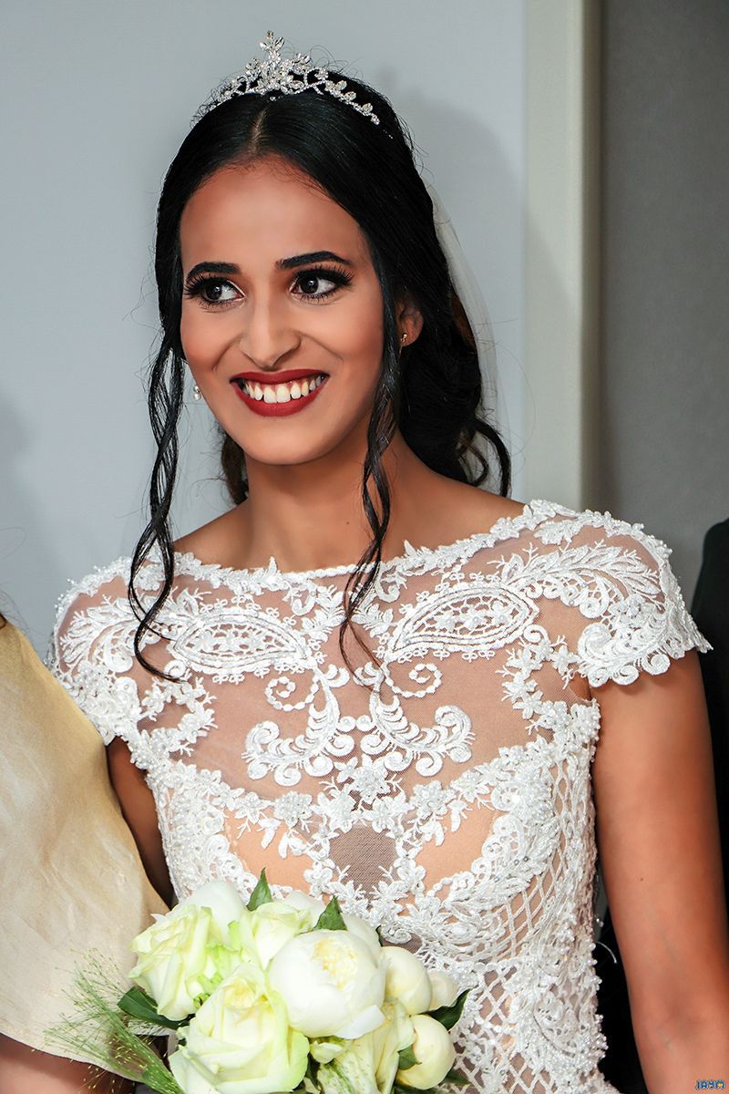 La mariée resplendit de bonheur dans sa tenue de cérémonie, capturée dans un instant de pure joie naturelle au cœur des festivités.