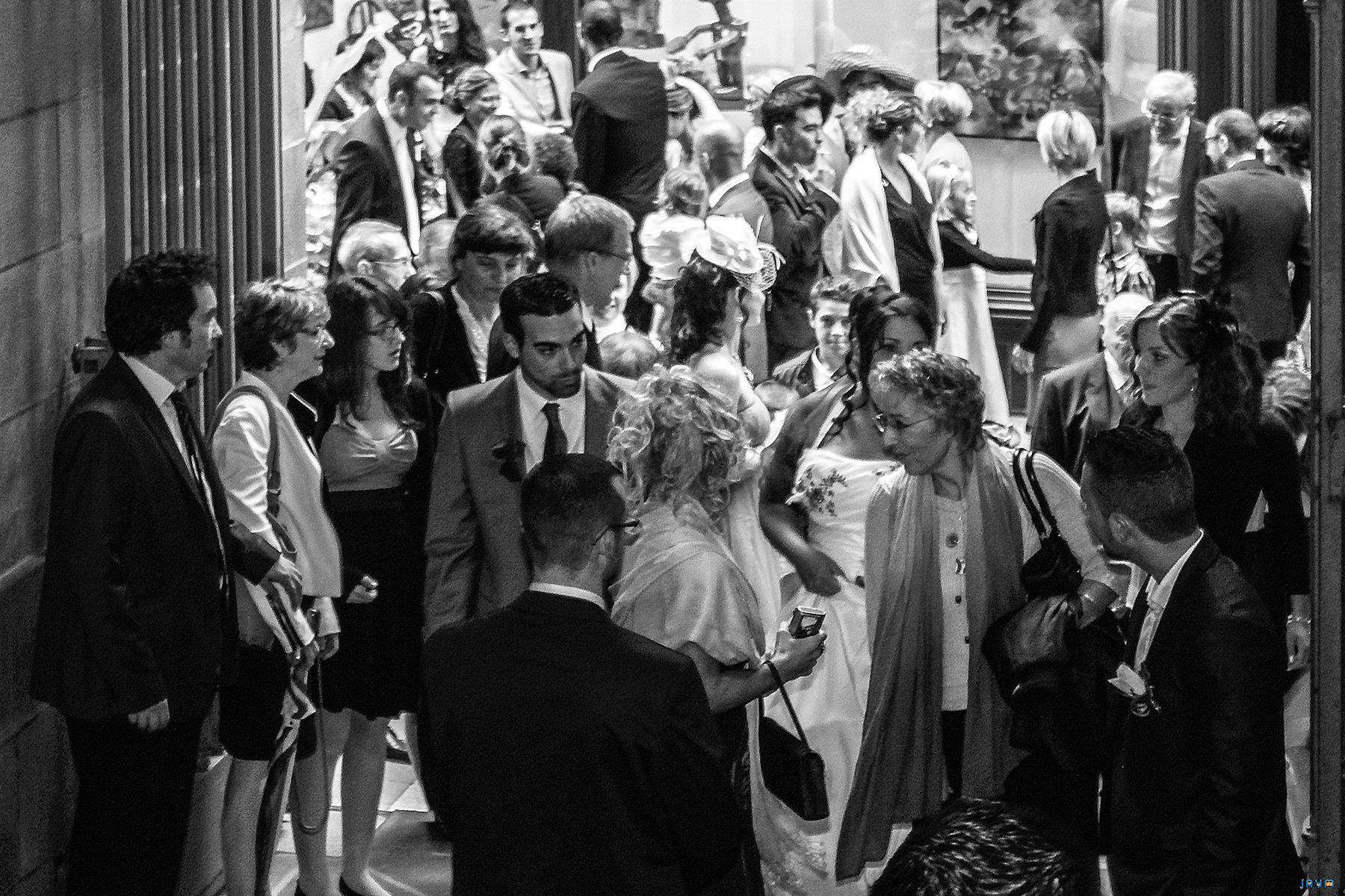 Les mariés, Clémentine et Nicolas, se mêlent à la foule de leurs invités dans une ambiance festive. Cette photographie en noir et blanc illustre la proximité et le partage au cœur de la célébration de leur union. Une immersion totale dans l'événement, symbolisant la réussite de ce mariage élégant à Clermont-Ferrand.