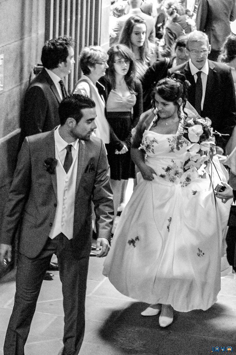 Les invités de Clémentine et Nicolas gravissent l'escalier monumental en pierre de Volvic. Cette photo en noir et blanc souligne la grandeur du patrimoine de Clermont-Ferrand, offrant un cadre prestigieux pour une réception de mariage. Un mélange parfait entre histoire et élégance contemporaine.