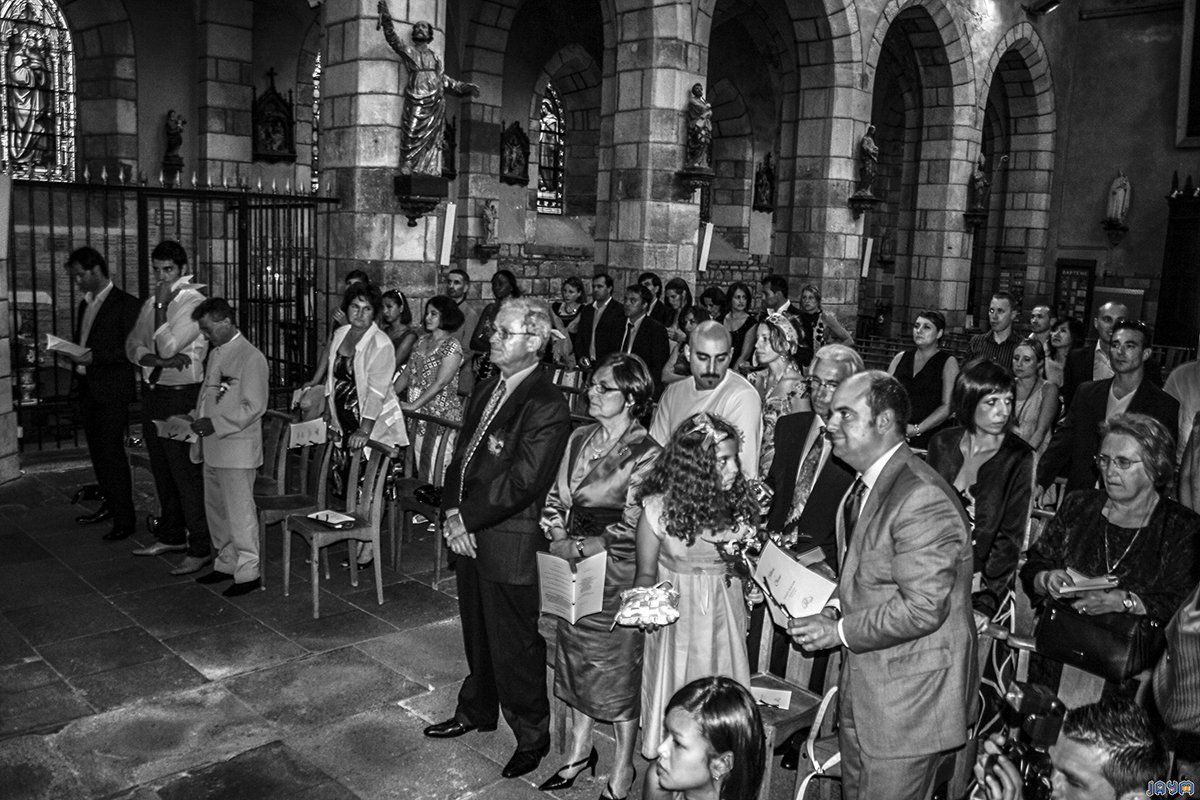 Tout les invités debout dans l'eglise de Vic-le-comte pour célébrer le mariage de Hélèna et Olivier.