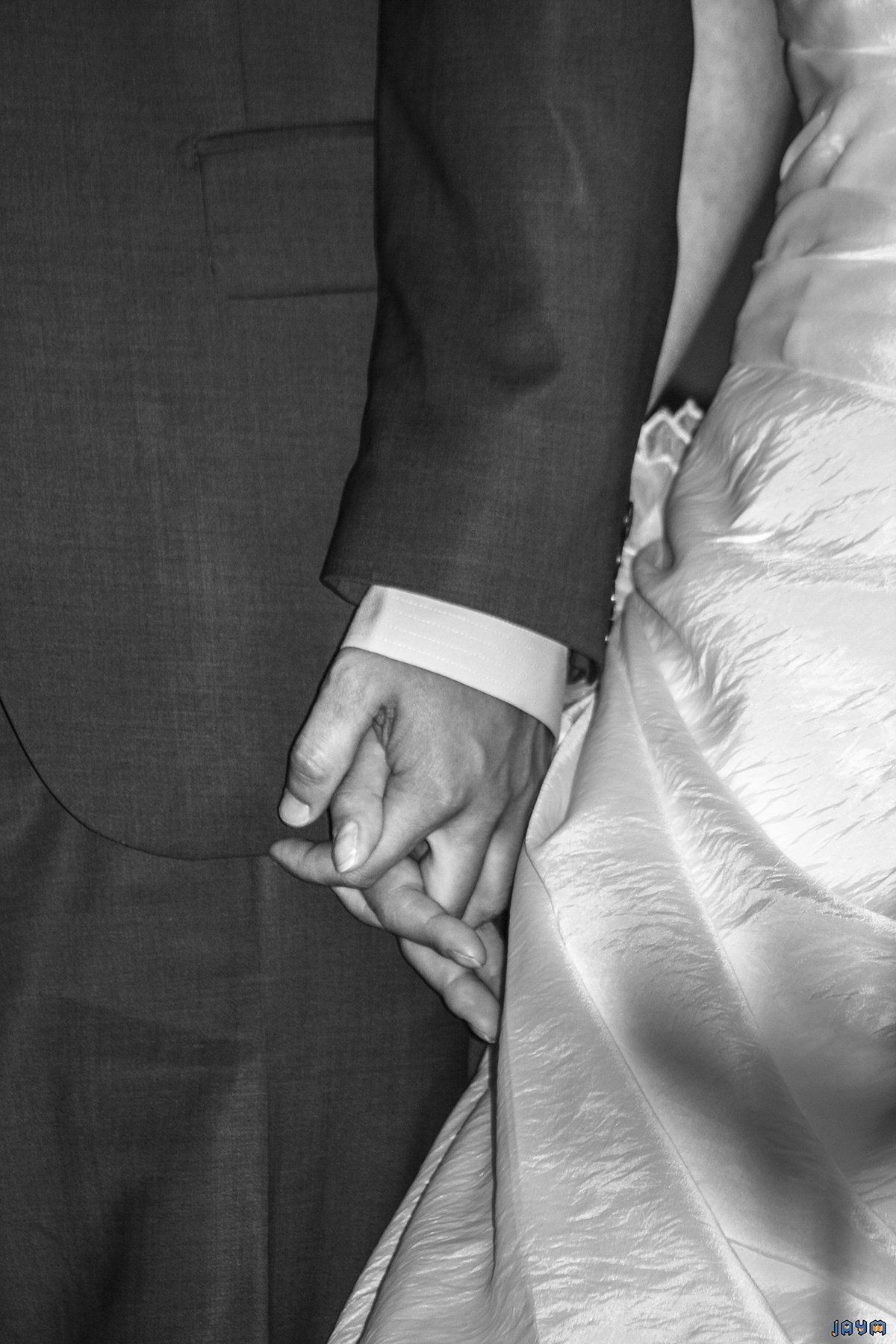 Gros plan sur les mariés qui se tiennent passionnement les mains.