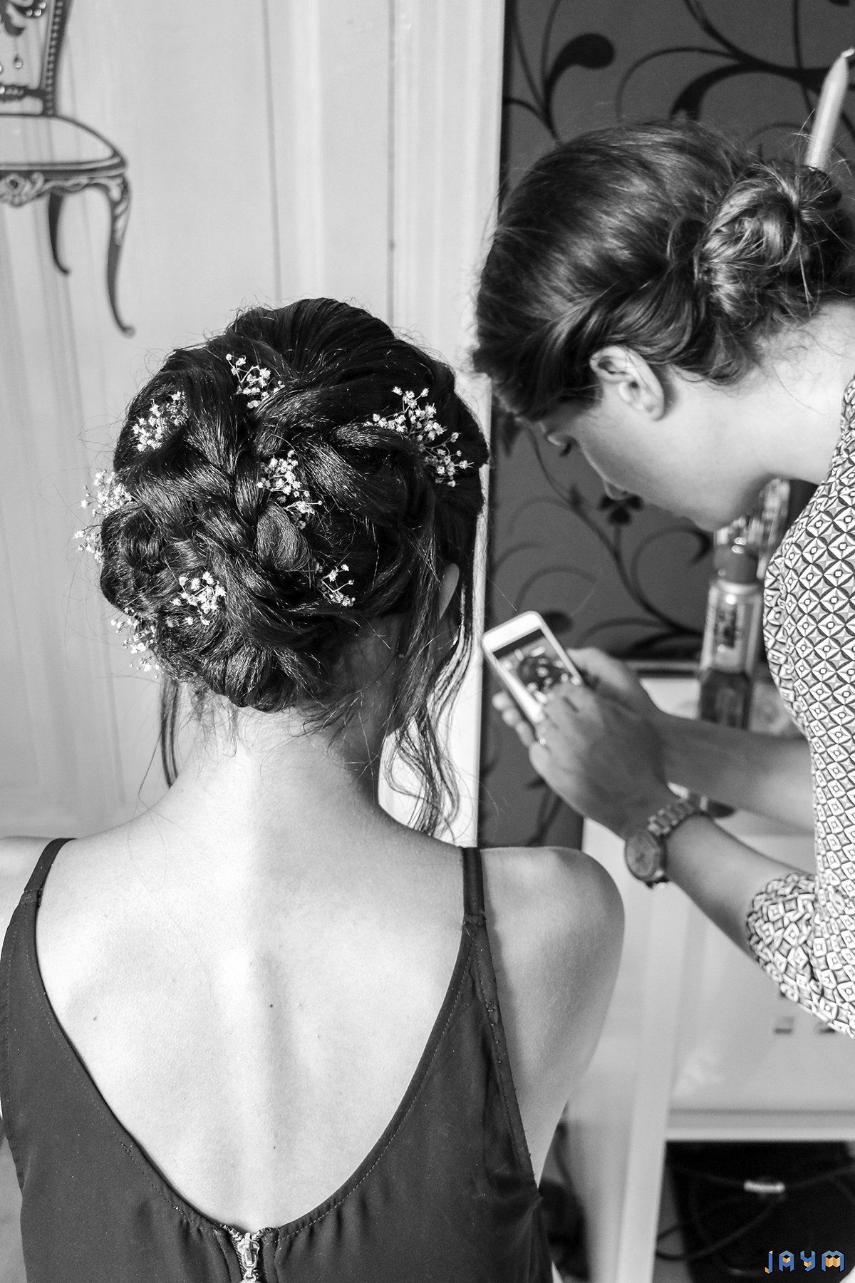 Vérification sur un portable de la bonne exécution de la coiffure de la mariée à Aulnat.