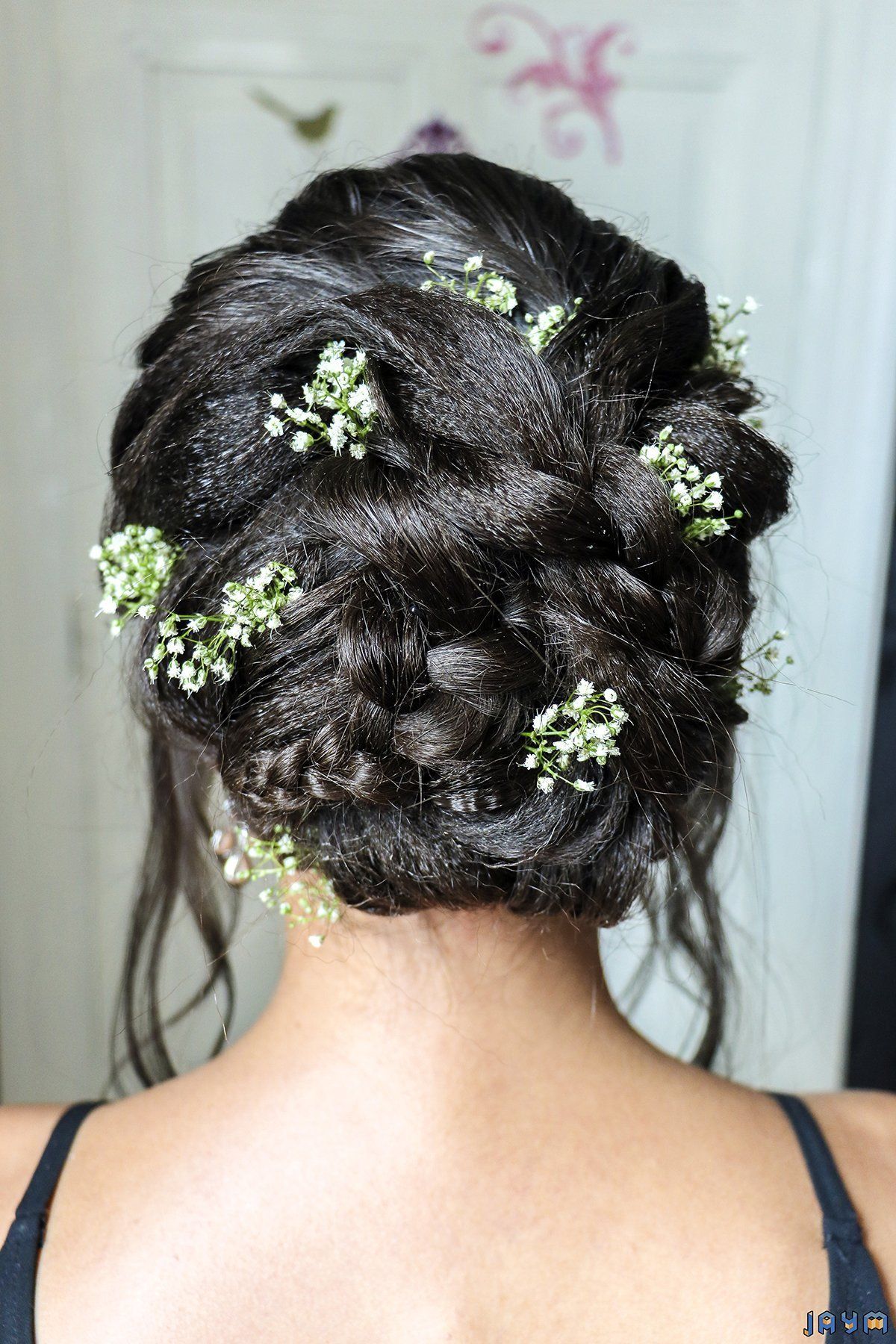 Un jolie chignon parsemé de petites fleurs blanches.