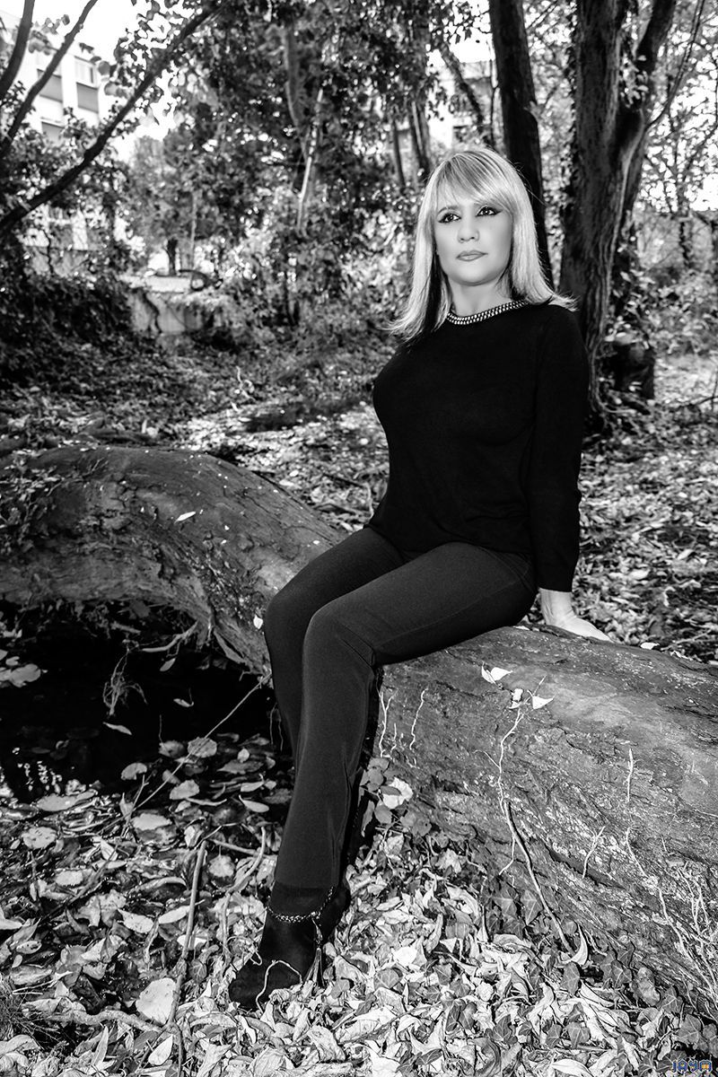 Femme mature assise sur un tronc mort