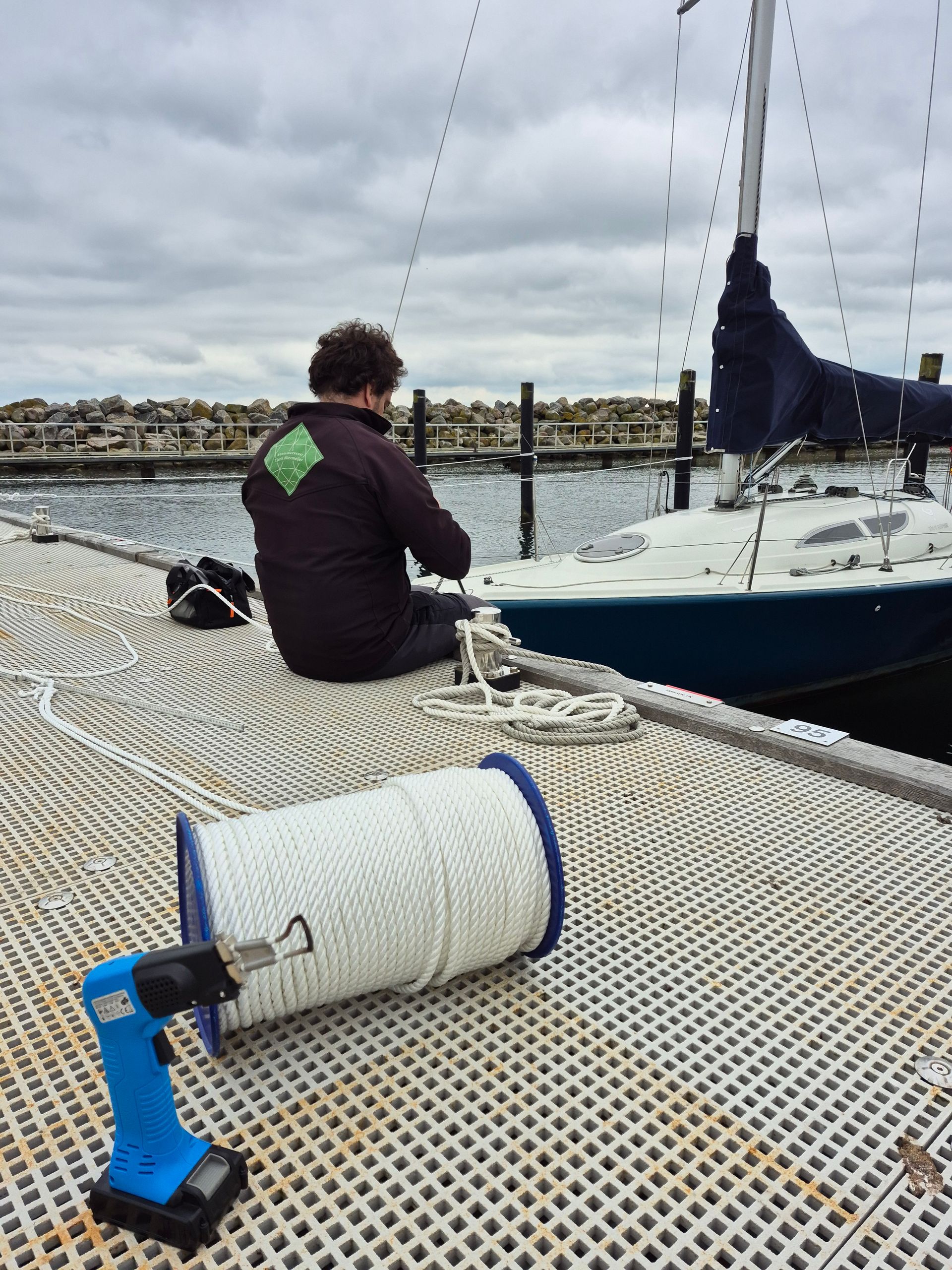 Segelmacher auf Steg beim Spleißen