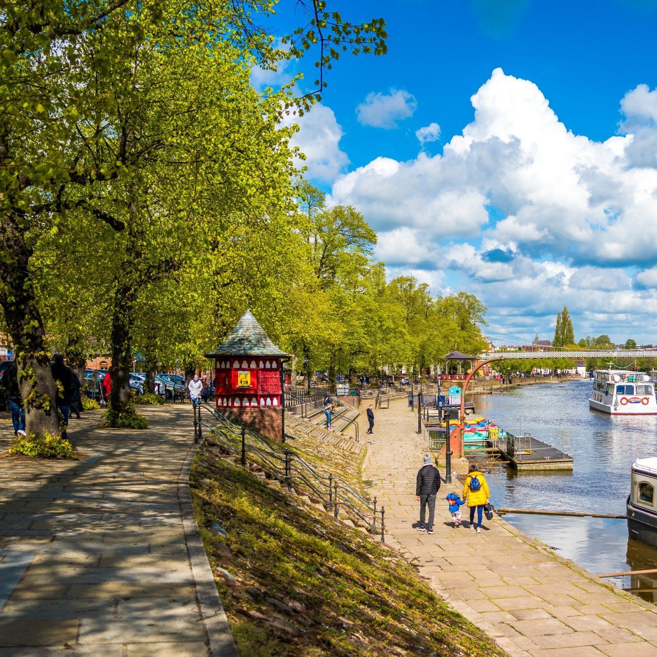 spring sun on the river dee and people rambling along the river