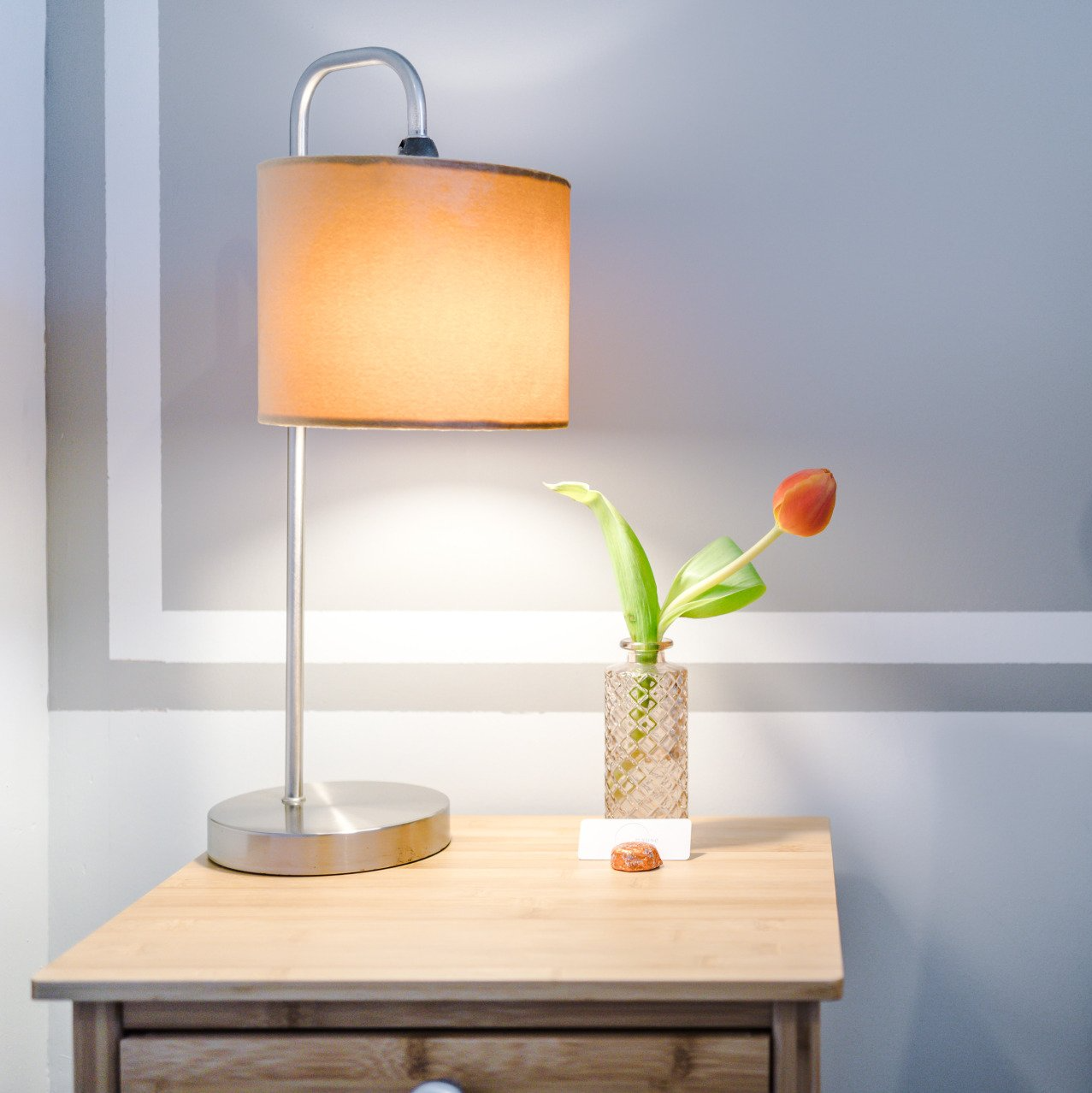 yellow side lamp and orange tulip in vase