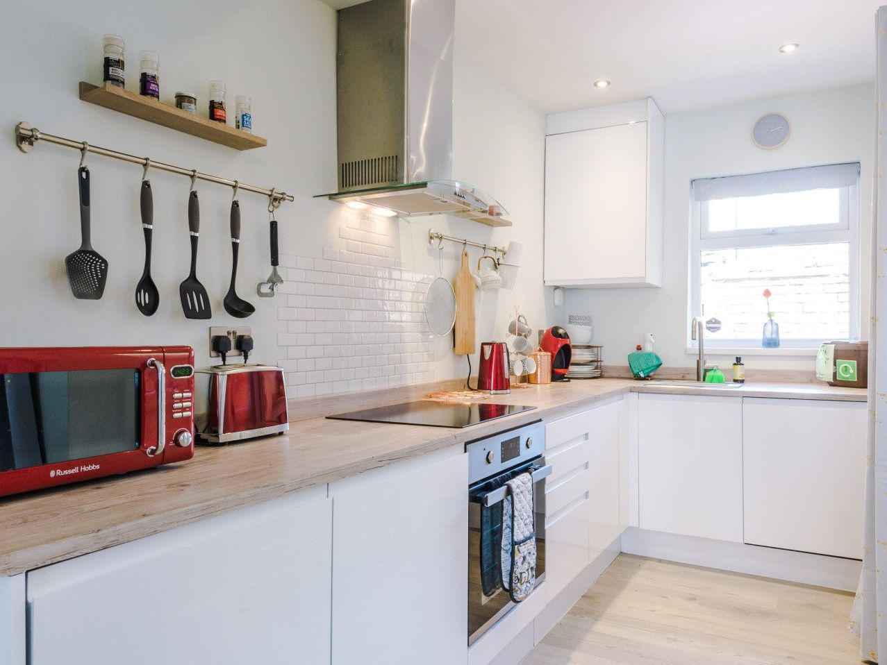 light kitchen with central hob and oven surrounded by small appliences