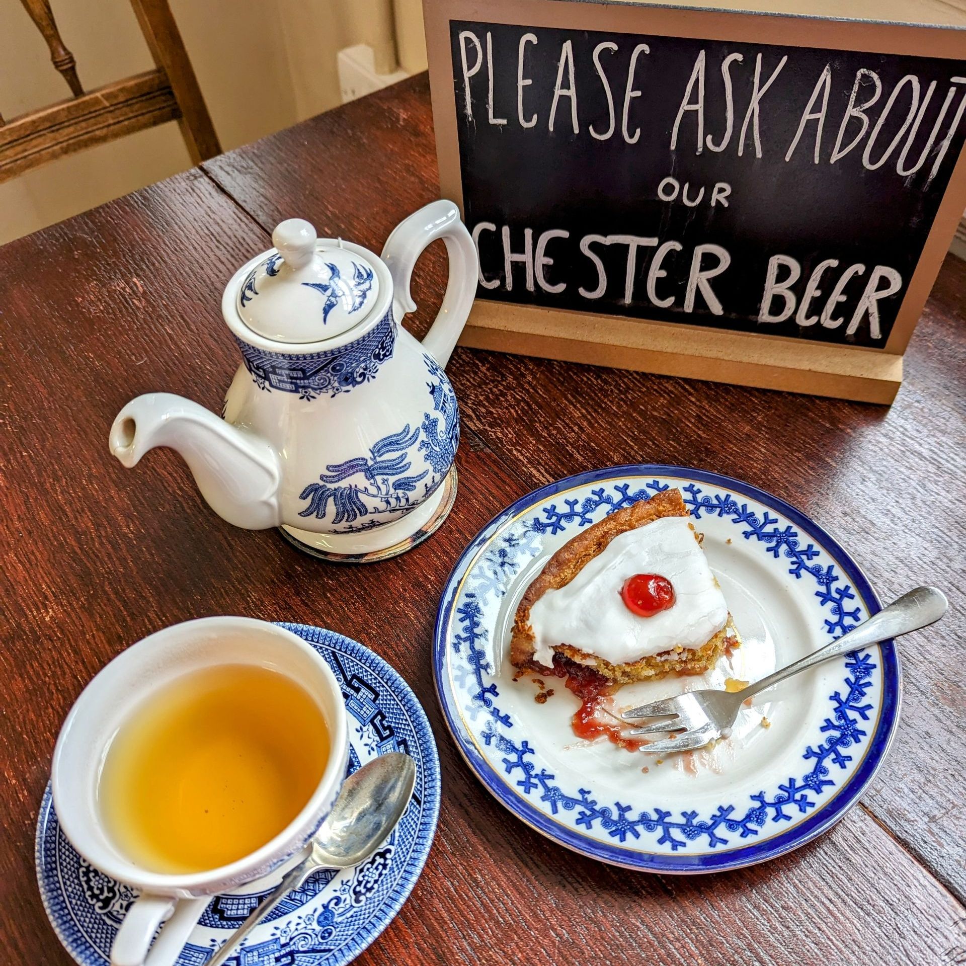 tea pot and cup of tea with a cherry cake