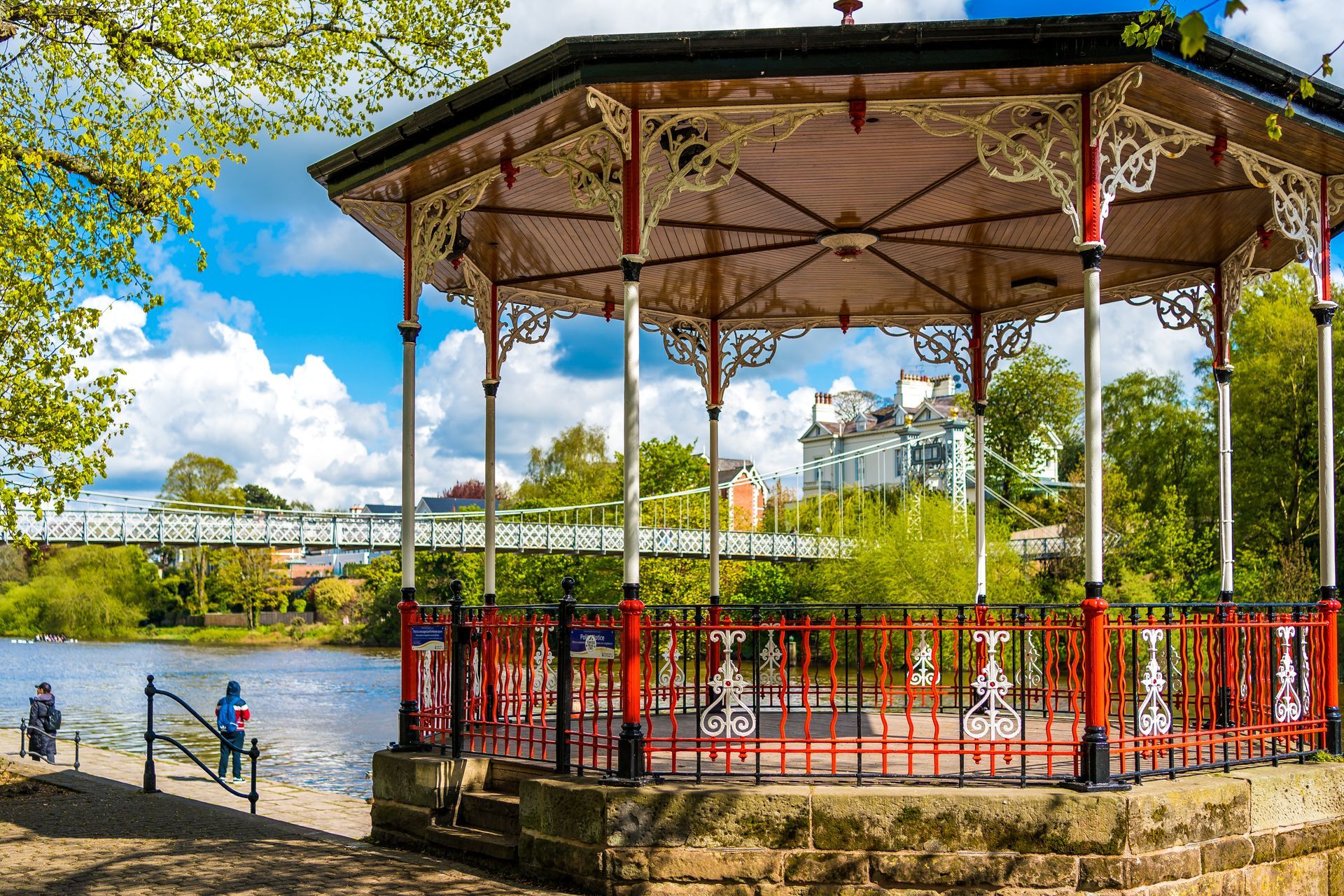 the red blank and white Victorian bandstand next to the river dee