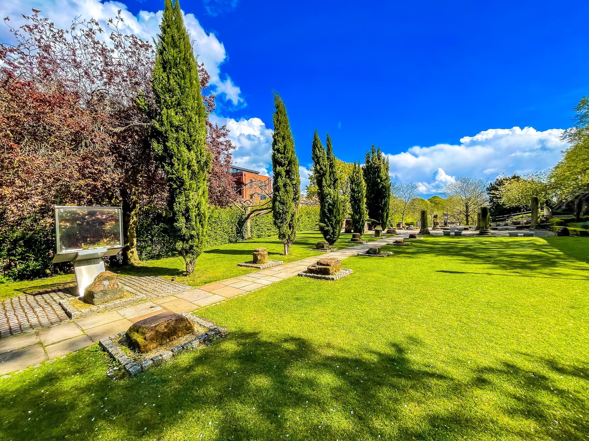 a spring day in the roman gardens with green grass, poplar and cherry blossom trees