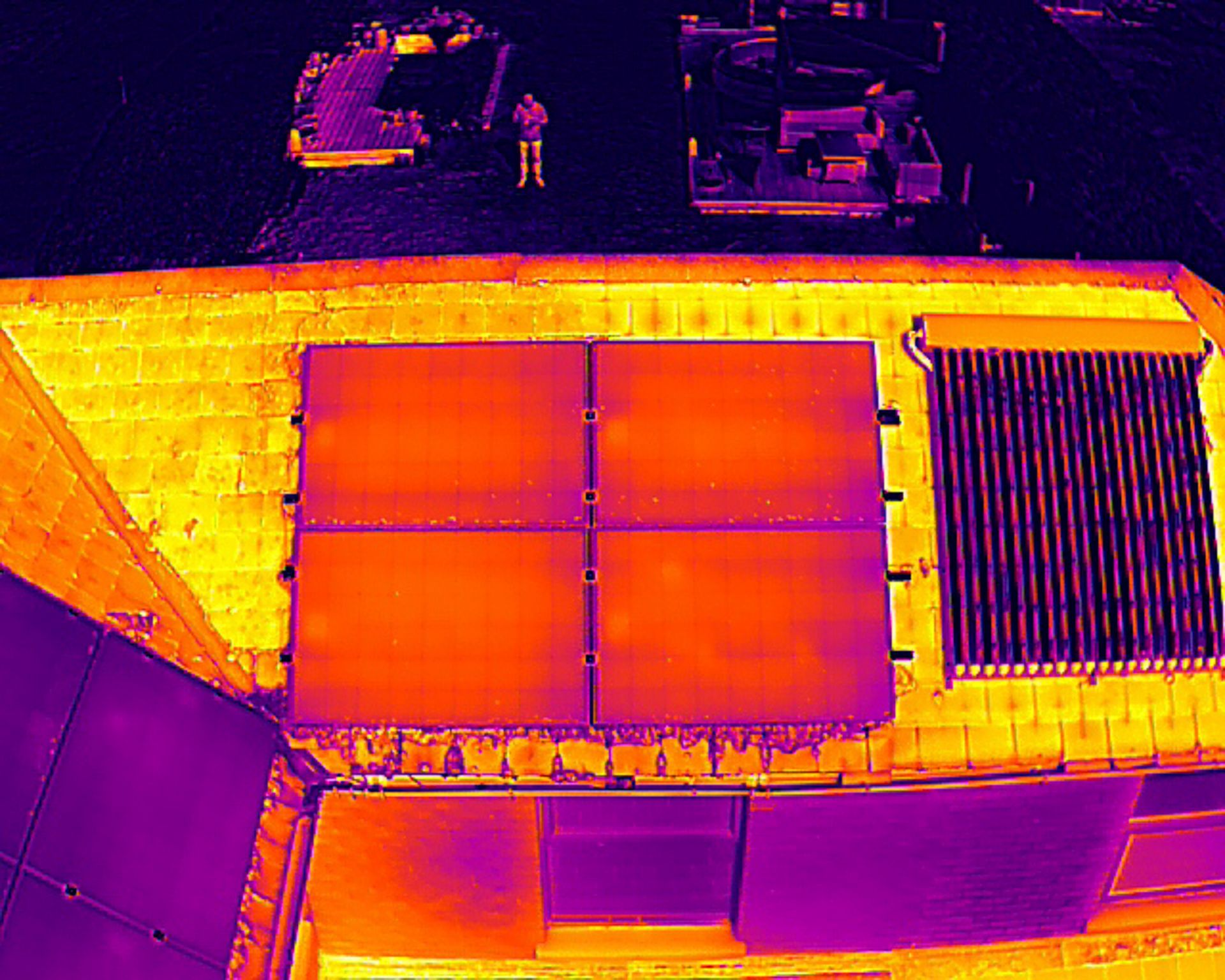 Thermal image of PV solar panels mounted on a house next to solar water heater.