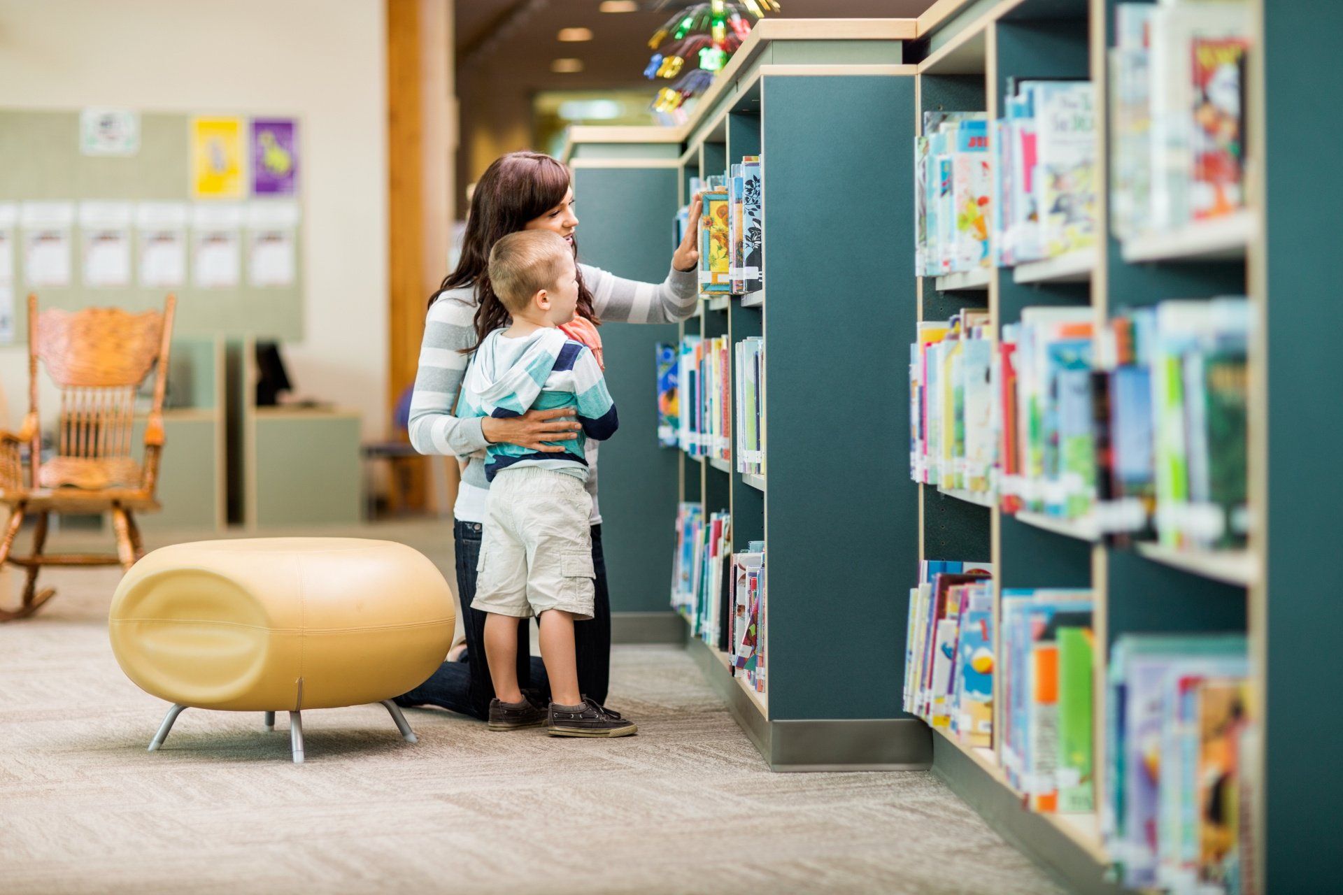 Une femme et son enfant dans les rayons d'une bibliothèque