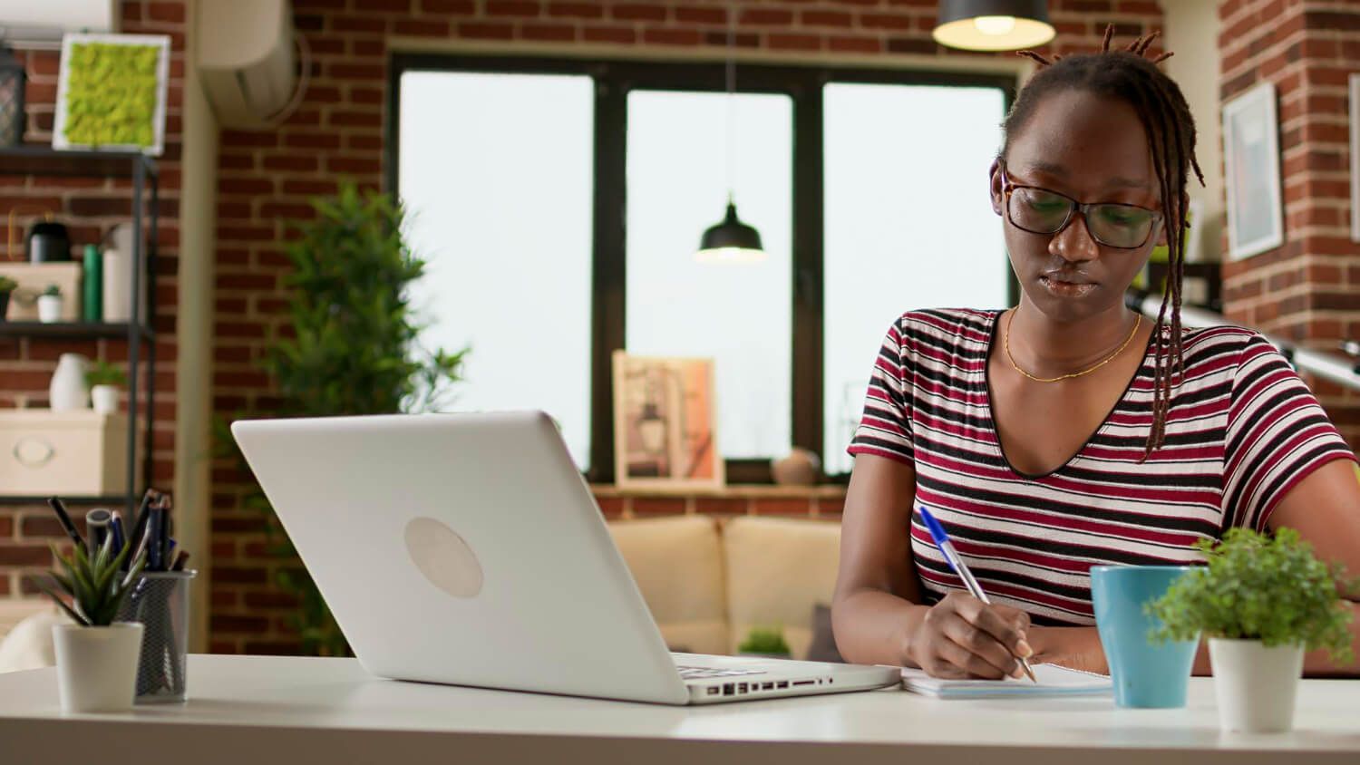 Adolescente qui prend des notes de ses cours scolaire en ligne