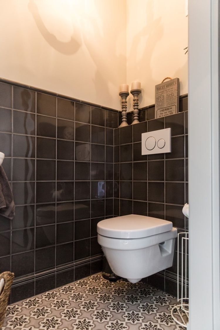 Gäste-WC schwarze Fliesen Bordüre Zementfliesen Toilette