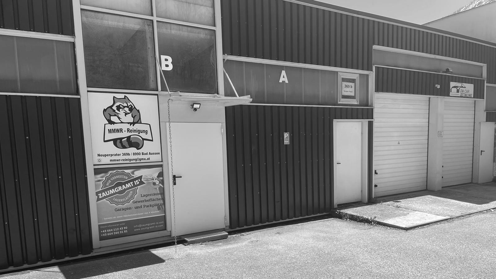 Vorderansich Lagerraum Bad Aussee, Neuperprater 369, 8990 Bad Aussee, Foto in Schwarz Weiß gehalten, Eingangstür, Garagentor geschlossen, Garagentor geöffnet