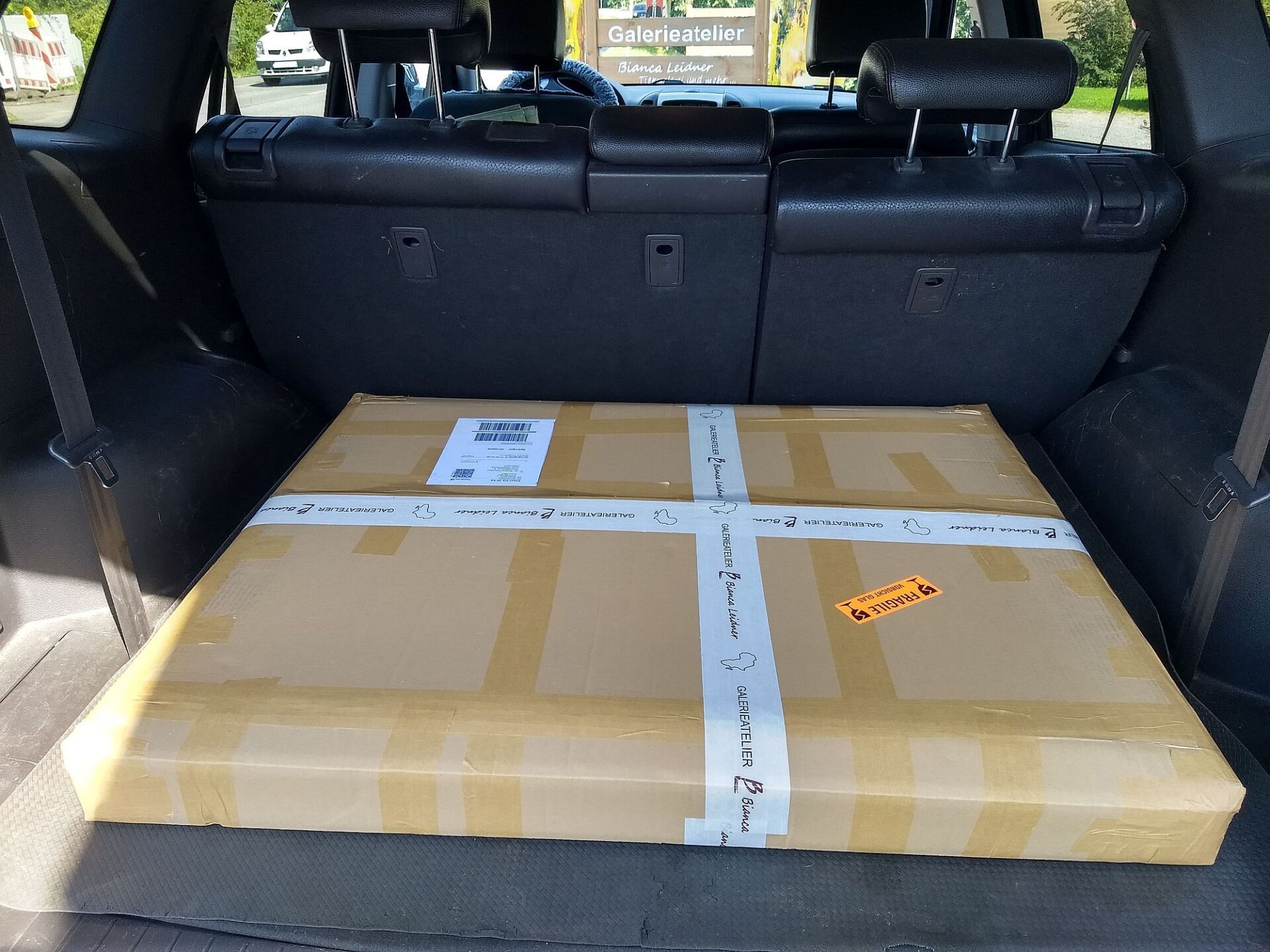 Ein sicher zum Versenden verpacktes Gemälde von Bianca Leidner im Kofferraum eines Autos