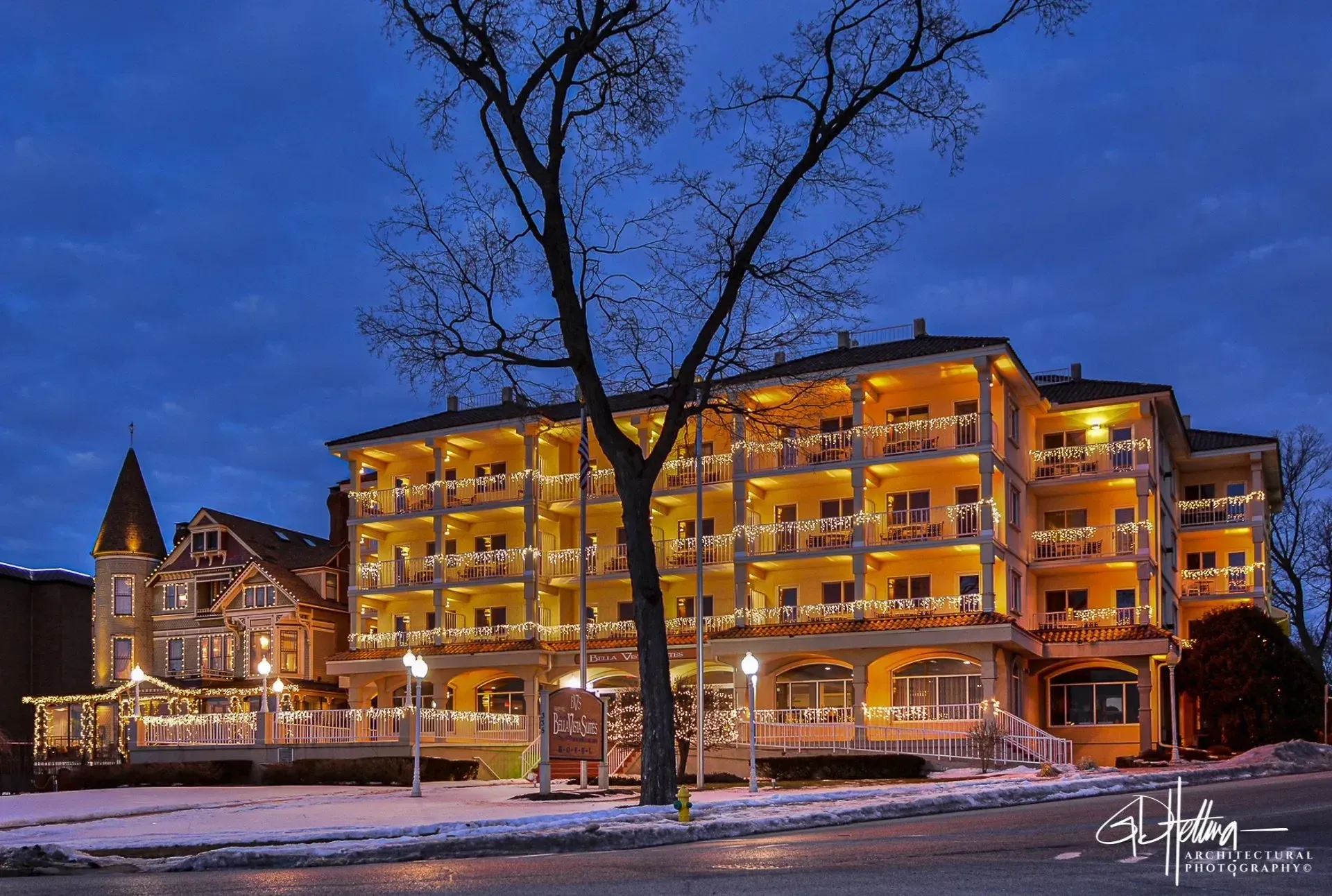Bella Vista Suites Hotel in Lake Geneva, Wisconsin, lakeside hotel at sunset with calm water reflections.