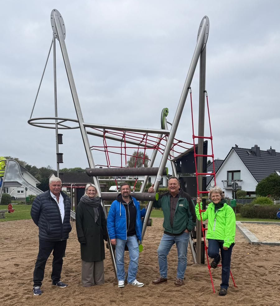 Fünf Menschen, die auf einem Spielplatz vor einem Kletterturm stehen Fünf Menschen, die auf einem Spielplatz vor einem Kletterturm stehen