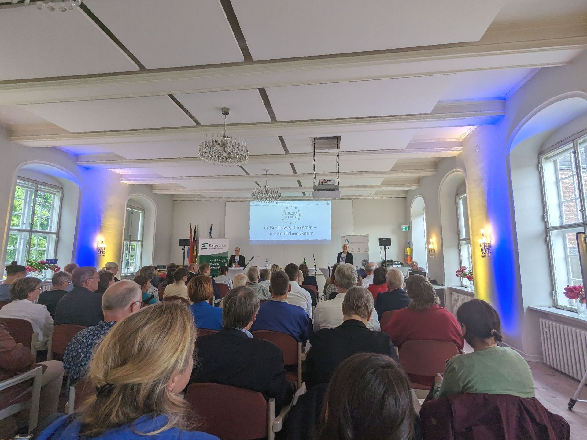 Menschen in einem Raum, die einem Vortrag zur Europawahl zuhören Menschen in einem Raum, die einem Vortrag zur Europawahl zuhören