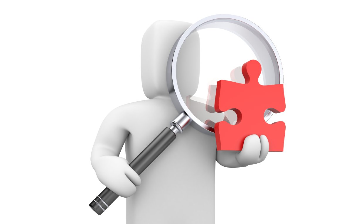 Weißes Männchen, das eine große Lupe und ein rotes Puzzleteil in der Hand hält