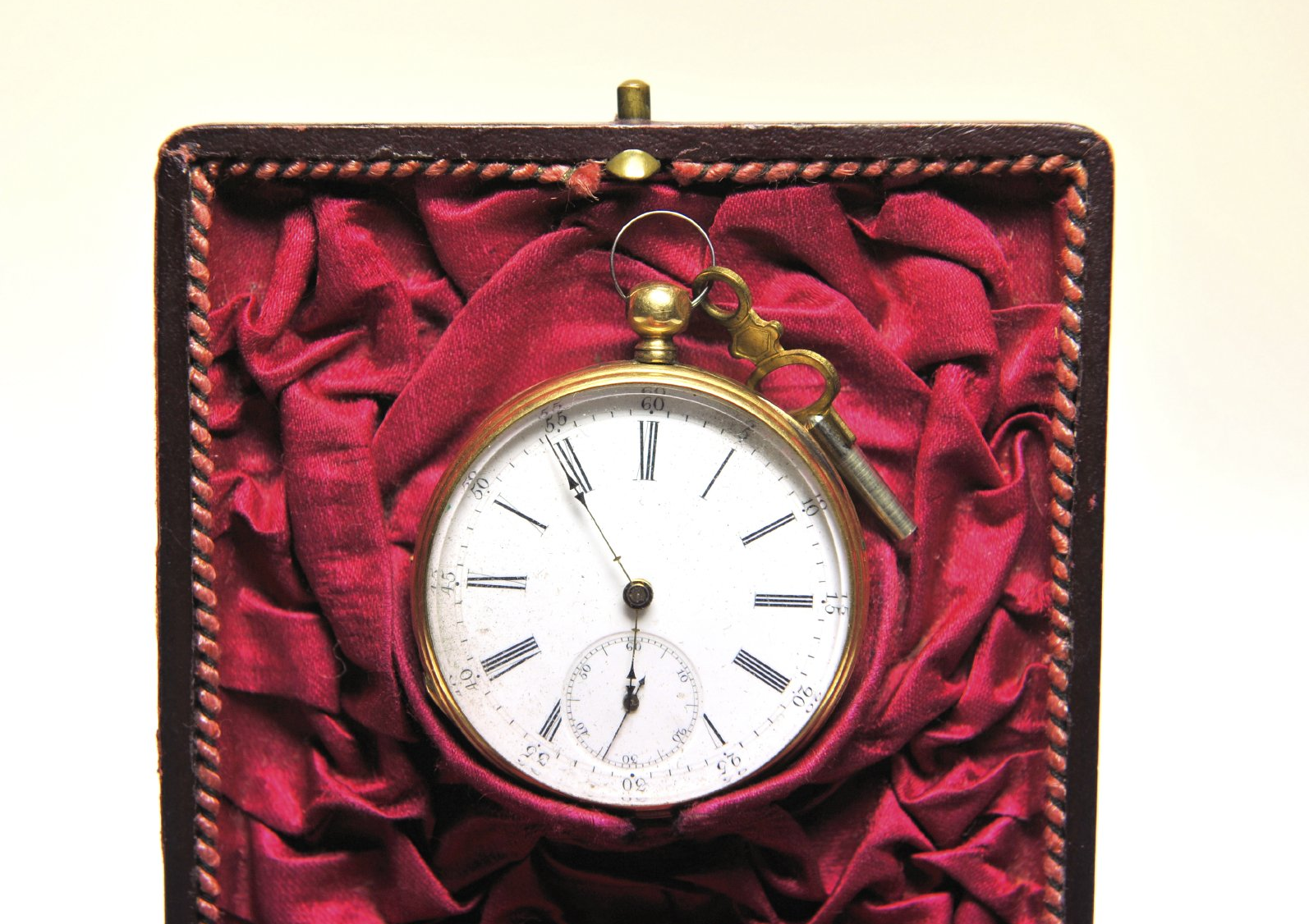 Schachtel mit rotem Tuch drin, darauf liegt eine Vintage Taschenuhr