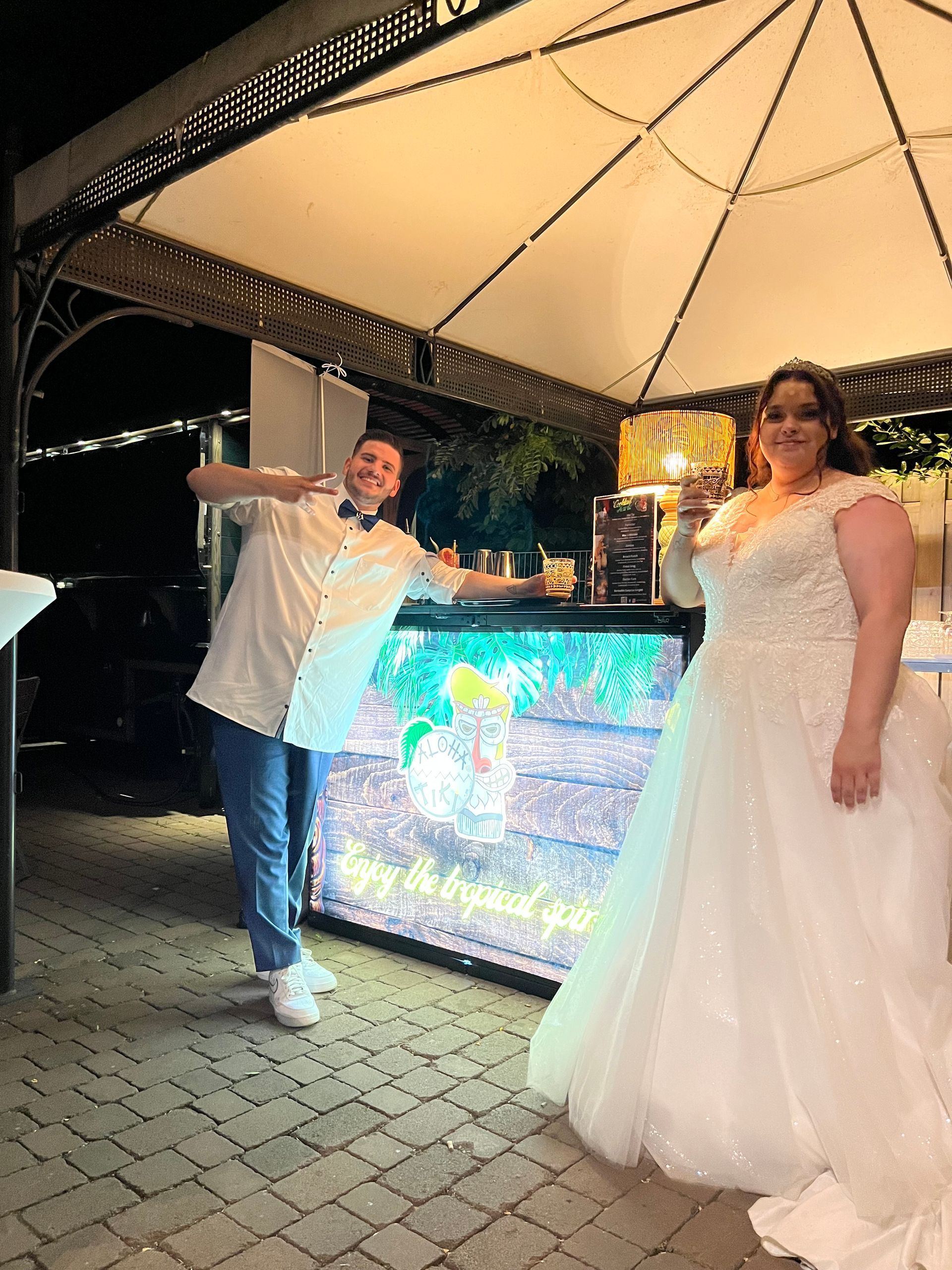 Brautpaar an der mobilen Alohatiki Cocktailbar bei einer Hochzeit mit tropischem Flair und exklusiven Drinks