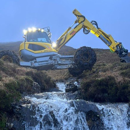 Menzi Muck Climbing over river spider excavator