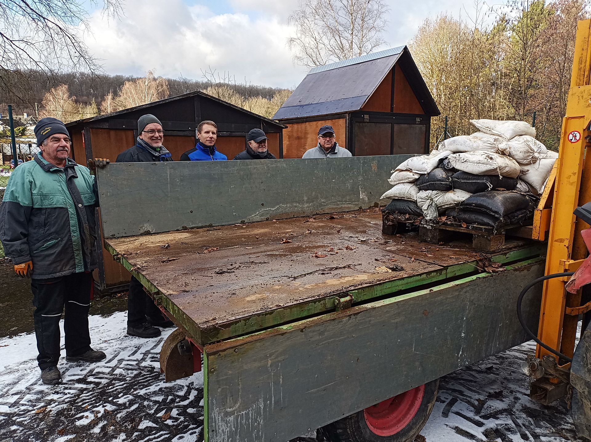 Ehrenamtliche Helfer hinter dem Anhänger mit Sandsäcken