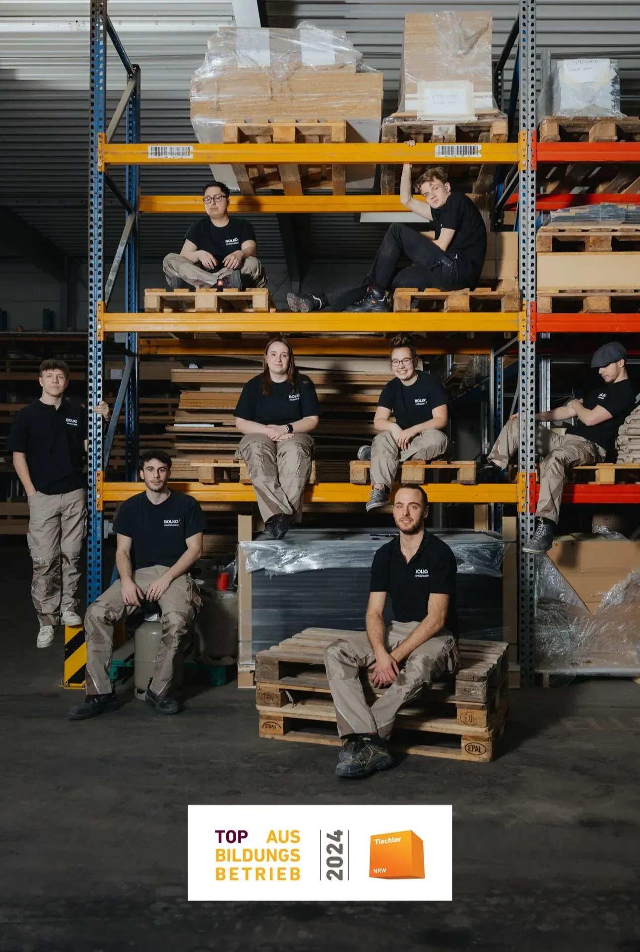 Azubis sitzen auf einem Gerüst