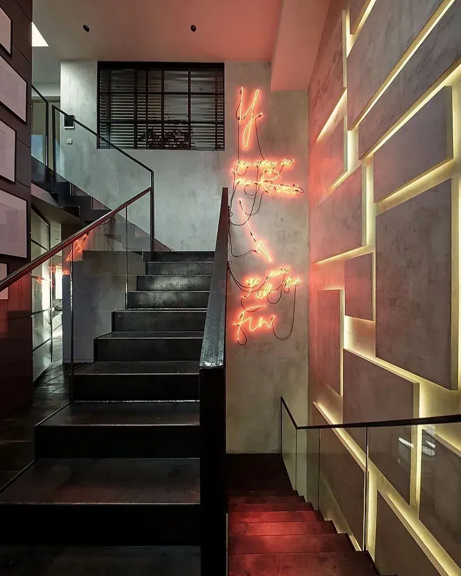 Treppenaufgang und Akzentwand mit Leuchtschrift