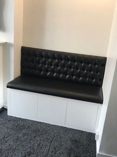 Built in bench seat in alcove with storage and deep buttoned upholstered backrest in Kew
