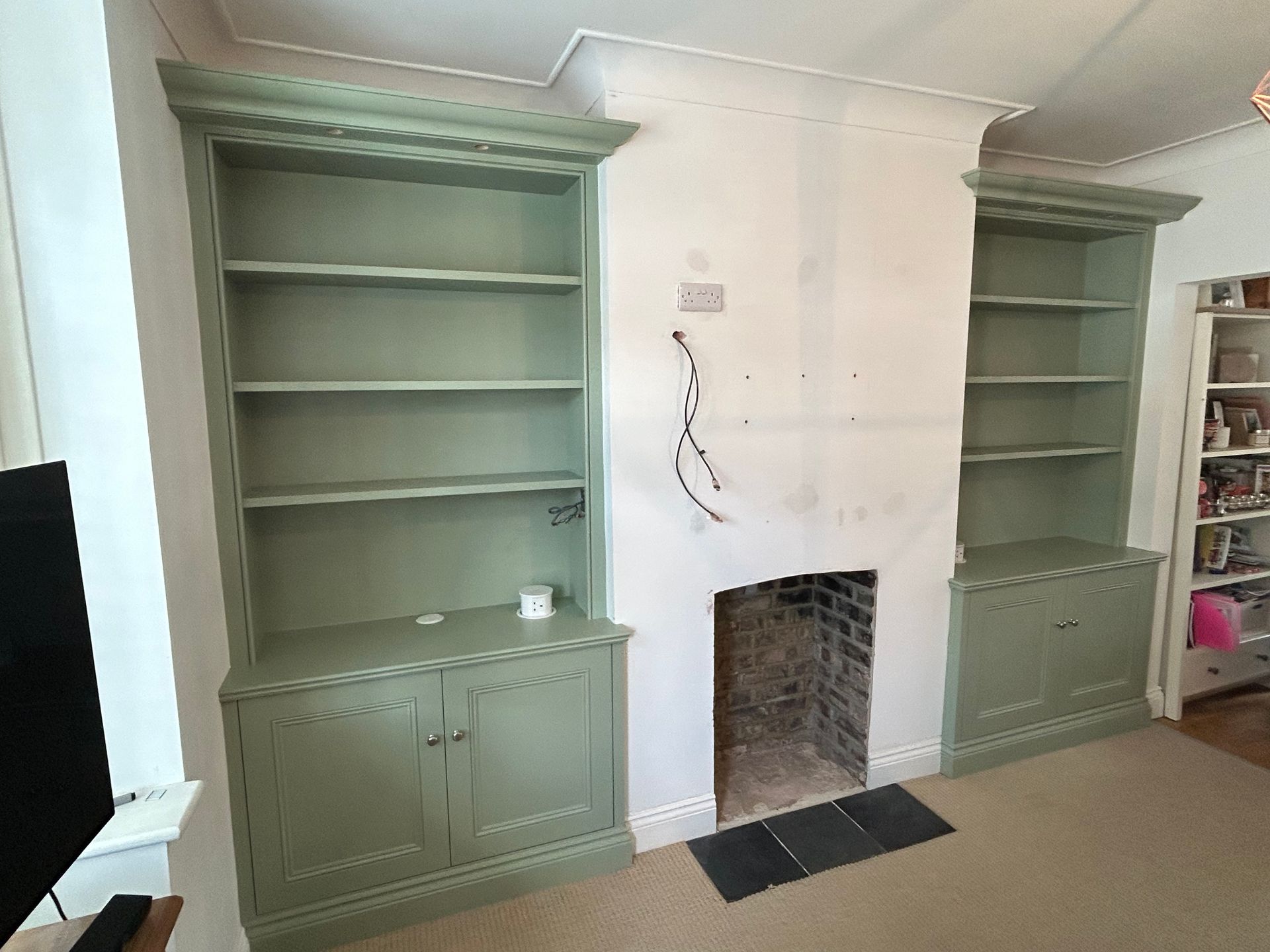 Traditional alcove cupboards and shelving with Victorian mouldings and canopy lighting in East Sheen