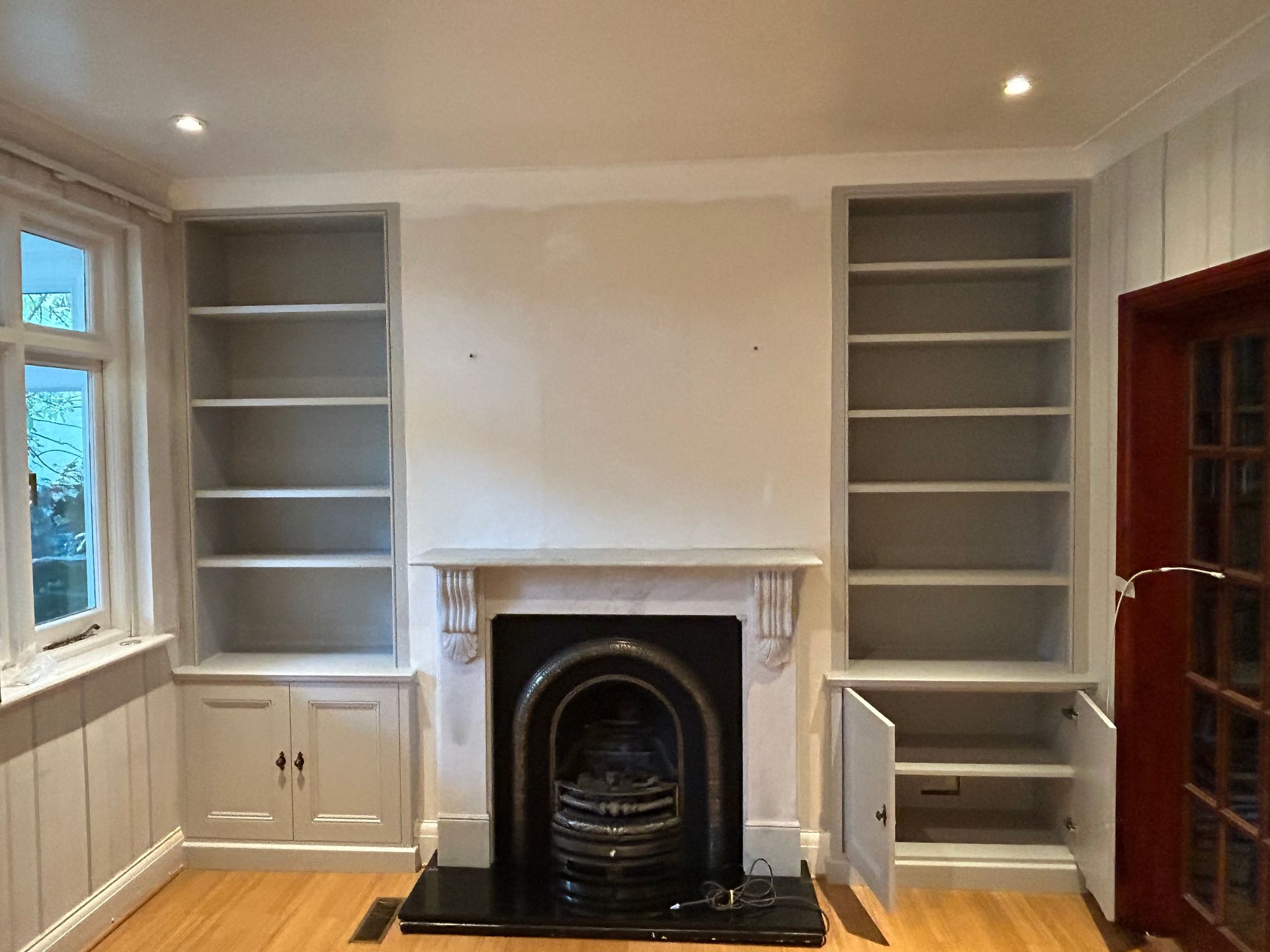 Full height alcove bookshelves and fitted cupboards beside chimney breast in Richmond