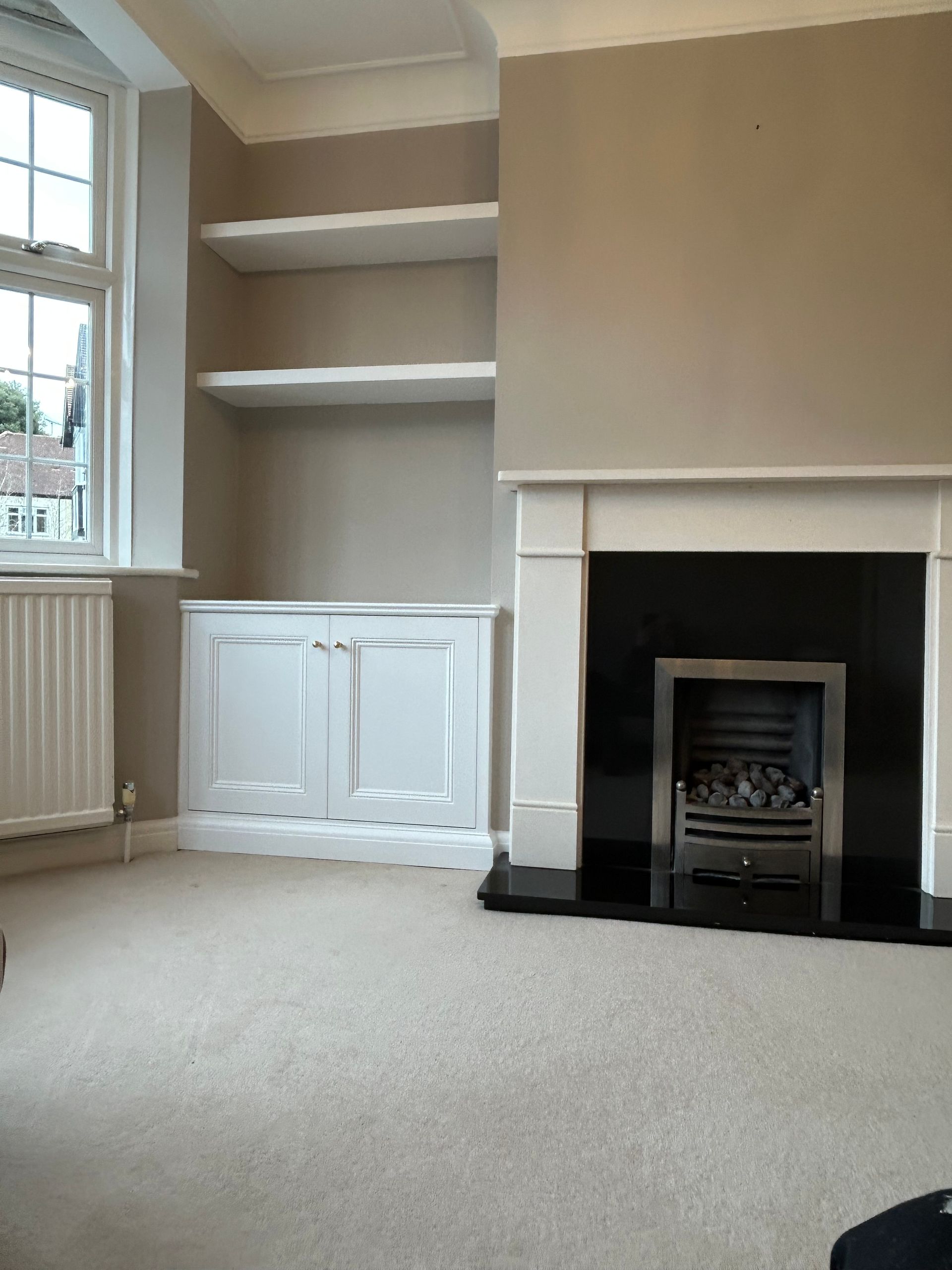 Traditional alcove cupboards and floating shelves in a chimney breast in Sheen