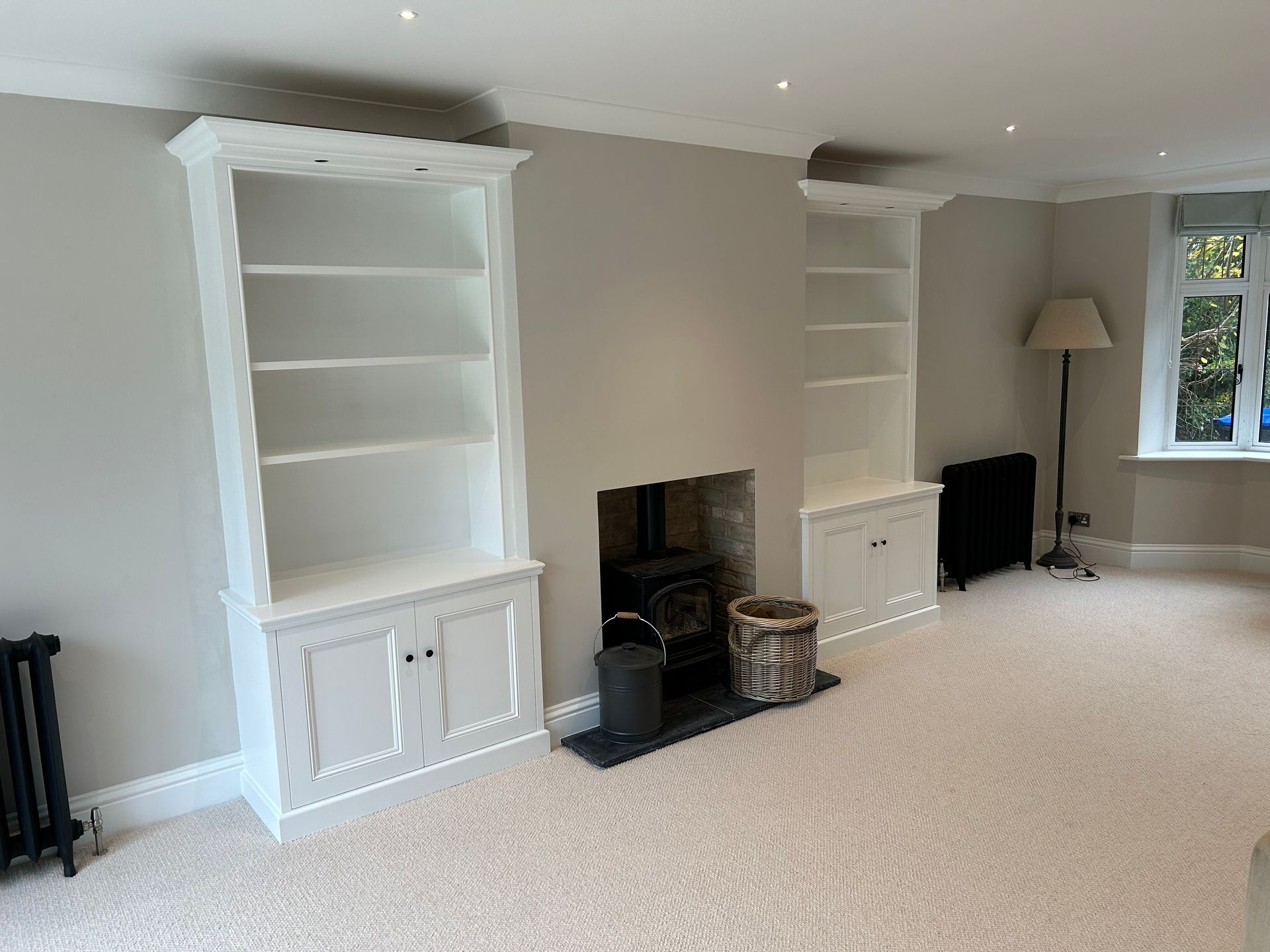 Traditional alcove cupboards with bespoke bookcase shelving and downlights in Kew
