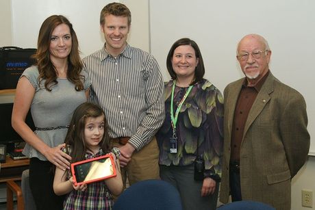 A child on the autism spectrum receives an iPad from the Elm Grove Golden K Kiwanis Club.