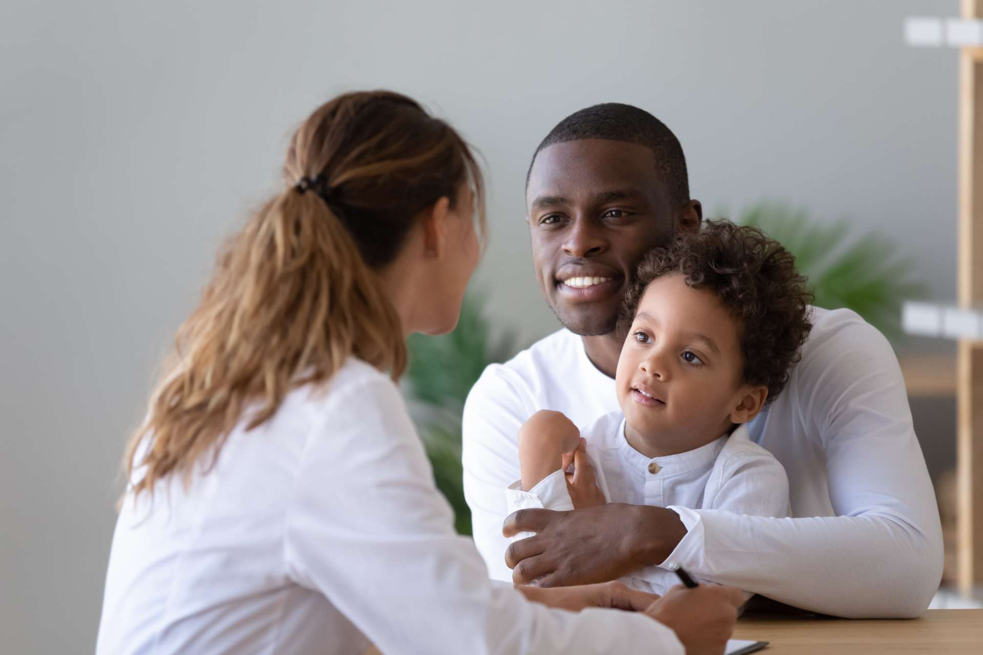 a father and child speaking with a nurse