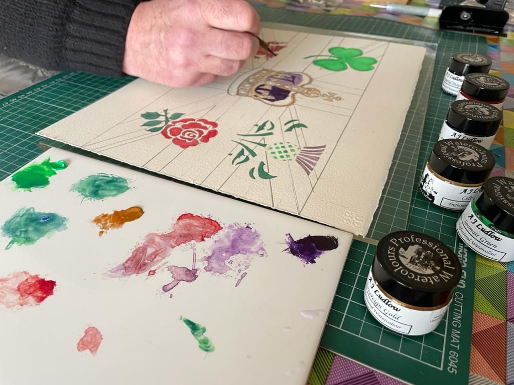Andrew, absorbed in adding the finishing touches to his watercolour painting design for the Colours of the United Kingdom Professional Watercolour Gift Set Painting with the watercolour paints from A J Ludlow Professional Watercolour set to celebrate the Coronation of HRH Charles III