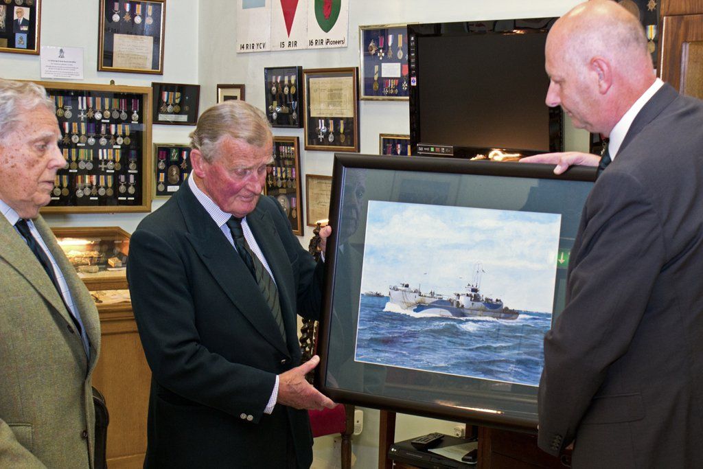 Andrew Ludlow at the RUR Museum, handing over his painting to Major-General Purdon, as Colonel Charley looks on Presenting the Trustees of the Royal Ulster Rifles Museum with the watercolour painting